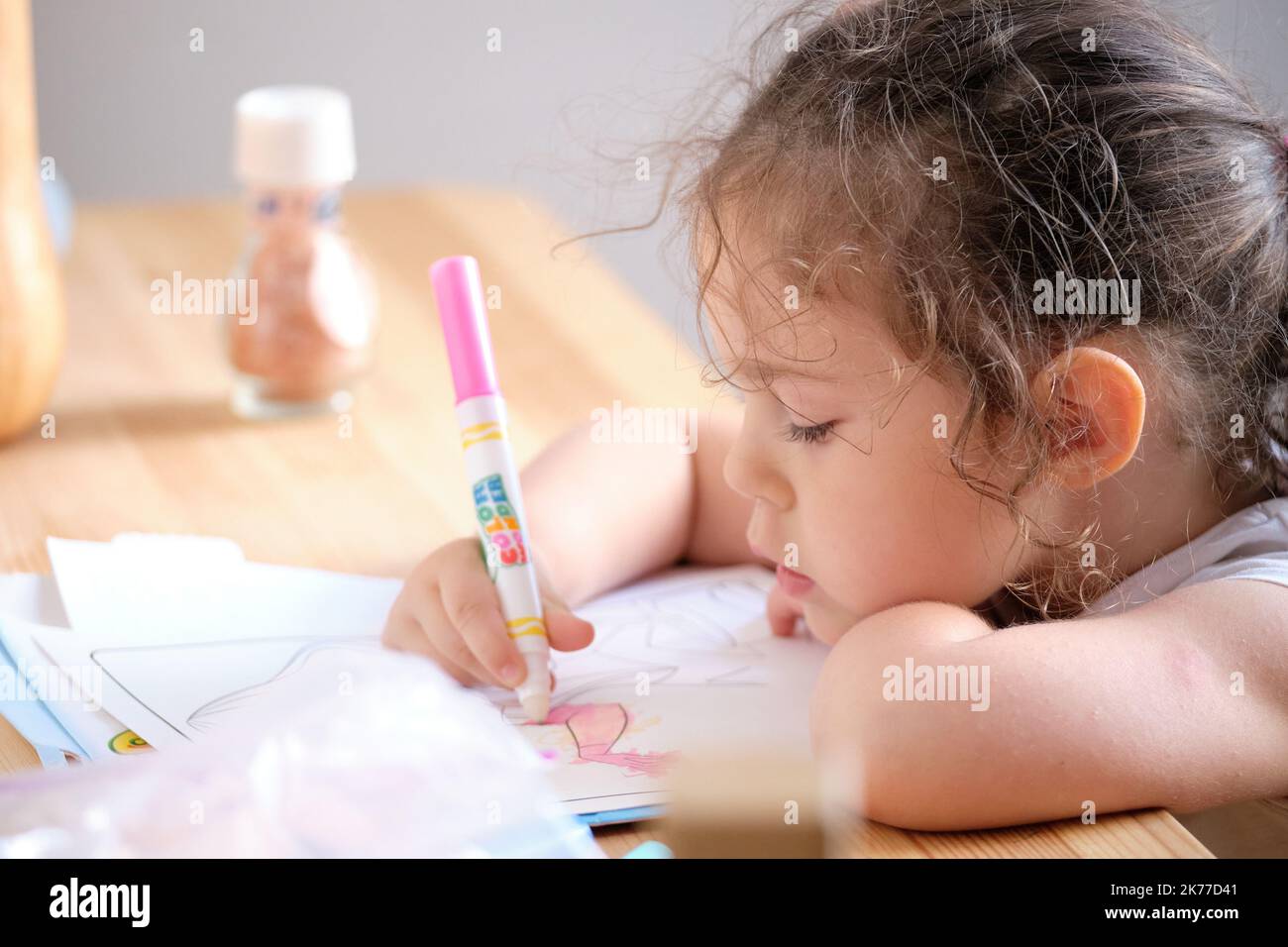 Bambina che gioca con inchiostro invisibile e libro da colorare Foto Stock