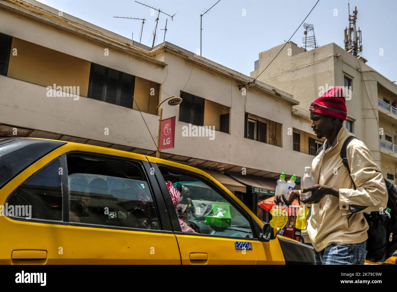 Senegal / Dakar / Dakar - un venditore di strada offre gel antibatterico ai clienti in un taxi nel centro di Dakar. Foto Stock