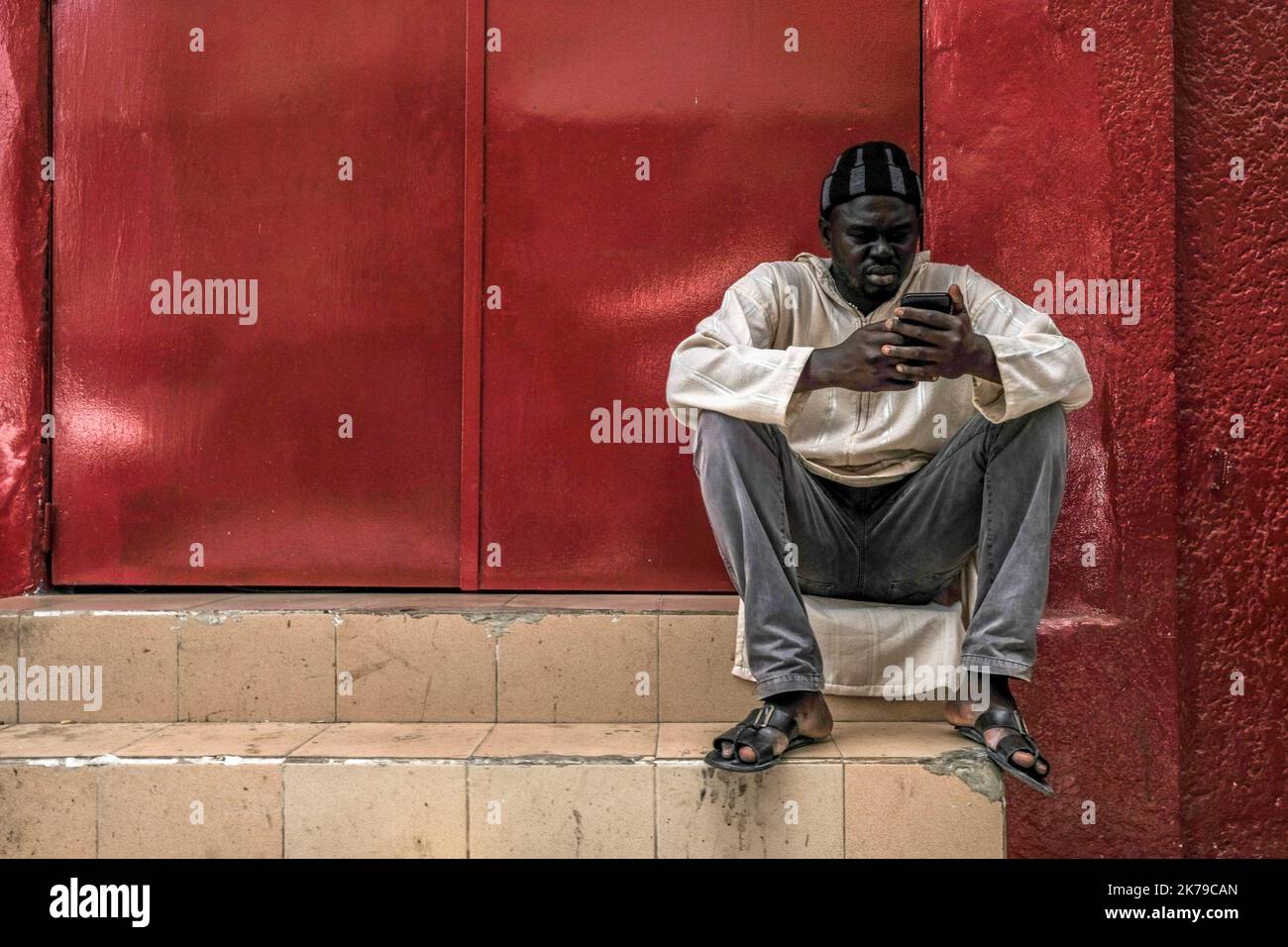 Senegal / Dakar / Dakar - un uomo attende l'apertura di un negozio di maschere nel centro di Dakar. Foto Stock