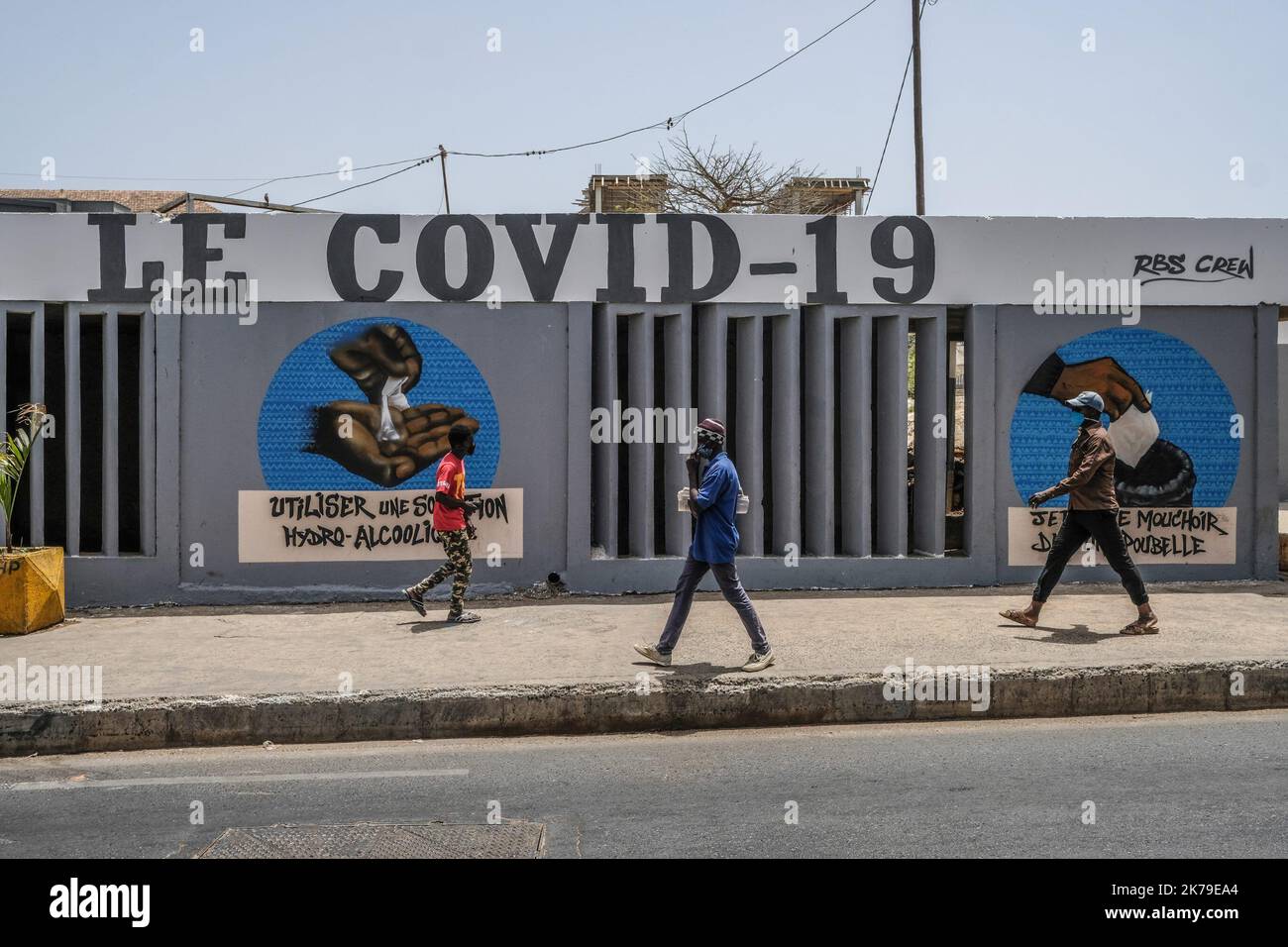 Senegal / Dakar / Dakar - i giovani passano davanti ai graffiti dipinti presso l'Università di Dakar per sensibilizzare sulle misure igieniche per combattere il Covid-19. Foto Stock