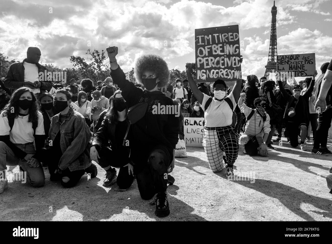 Francia / Ile-de-France (regione) / Parigi - i manifestanti alzano i pugni in aria e si inginocchiano a terra per rendere omaggio a George Floyd durante un rally contro la violenza della polizia e il razzismo negli Champs de Mars., George Floyd morì durante il suo arresto da un poliziotto bianco, Derek Chauvin, 25 maggio 2020 a Minneapolis, Minnesota negli Stati Uniti. Recenti indagini sul razzismo nella polizia sono state appena pubblicate sulla stampa francese e trovano eco nella morte di George Floyd negli Stati Uniti. In molti paesi, le proteste sono in risposta alla morte di George Floyd. Foto Stock