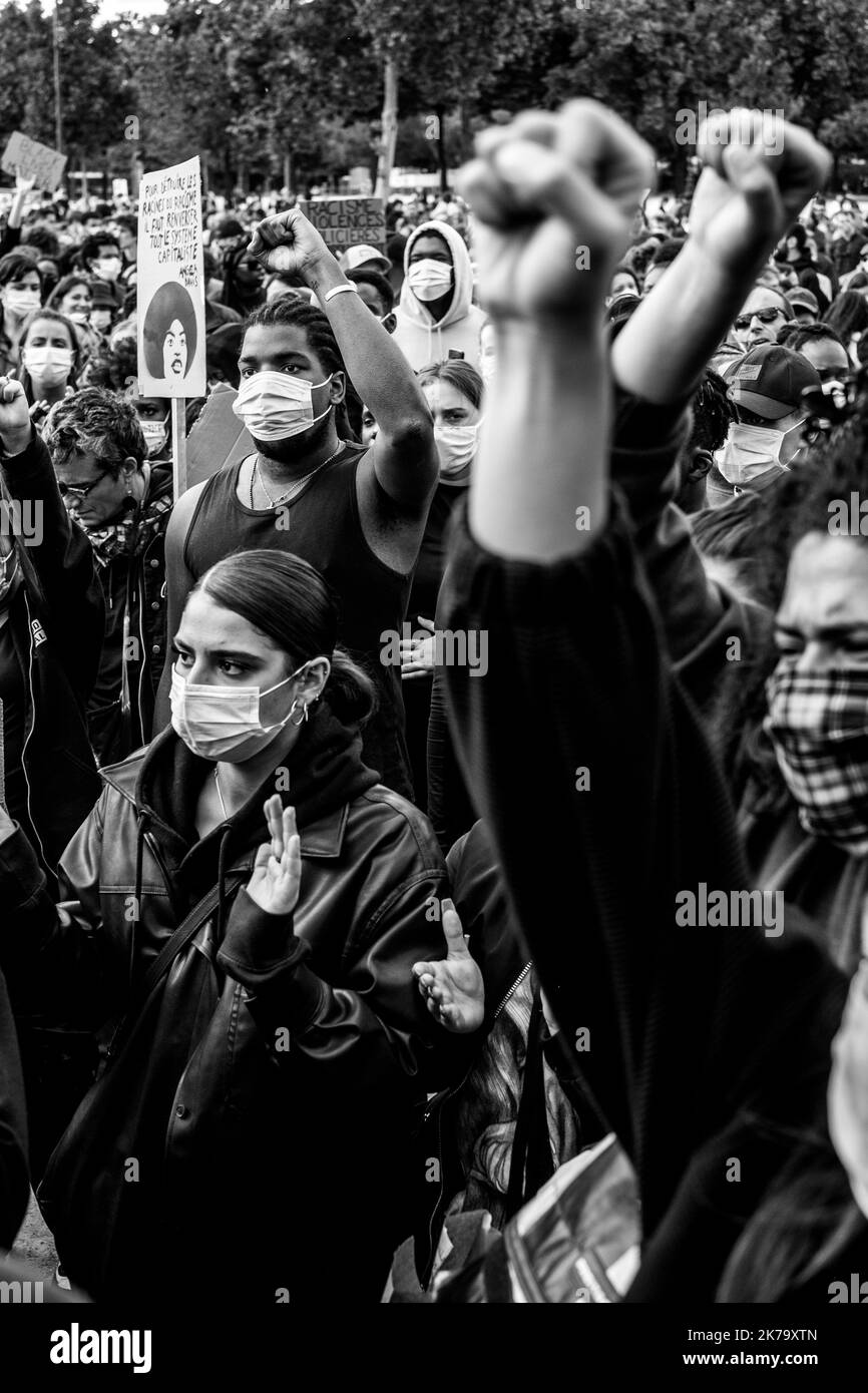 Francia / Ile-de-France (regione) / Parigi - i manifestanti alzano i pugni in aria e si inginocchiano a terra per rendere omaggio a George Floyd durante un rally contro la violenza della polizia e il razzismo negli Champs de Mars., George Floyd morì durante il suo arresto da un poliziotto bianco, Derek Chauvin, 25 maggio 2020 a Minneapolis, Minnesota negli Stati Uniti. Recenti indagini sul razzismo nella polizia sono state appena pubblicate sulla stampa francese e trovano eco nella morte di George Floyd negli Stati Uniti. In molti paesi, le proteste sono in risposta alla morte di George Floyd. Foto Stock