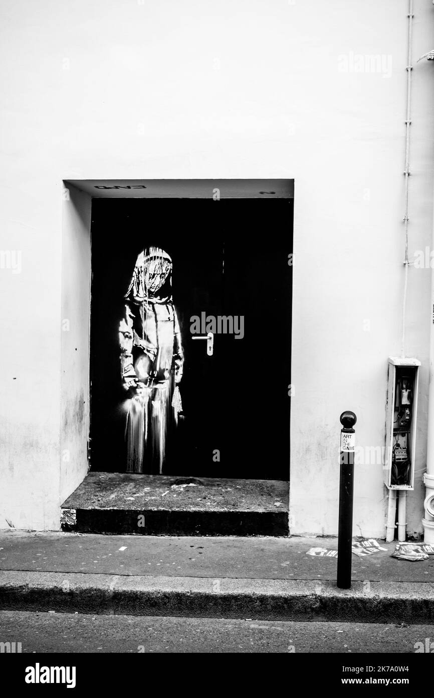 Una delle opere di Banksy. L'artista ha appena fatto la sua prima visita a Parigi. Qui, uno dei suoi stencil mostra una giovane ragazza che sembra piangere. È avvolto in una sorta di protezione. Lo stencil è stato fatto su una porta che porta al Bataclan, la sala concerti, l'obiettivo di un attacco jihadista che ha lasciato 90 morti il 13 novembre 2015. Giugno 26, 2018. Parigi. Francia. Foto Stock