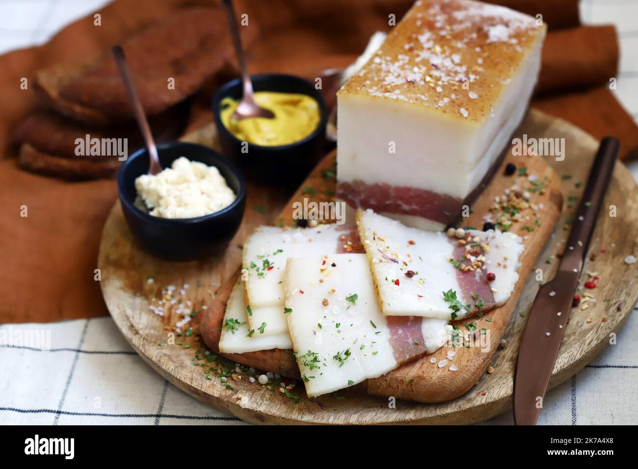 Strutto fresco con strato di carne su un asse di legno con spezie, senape e rafano. Snack delizioso. Pancetta. Foto Stock