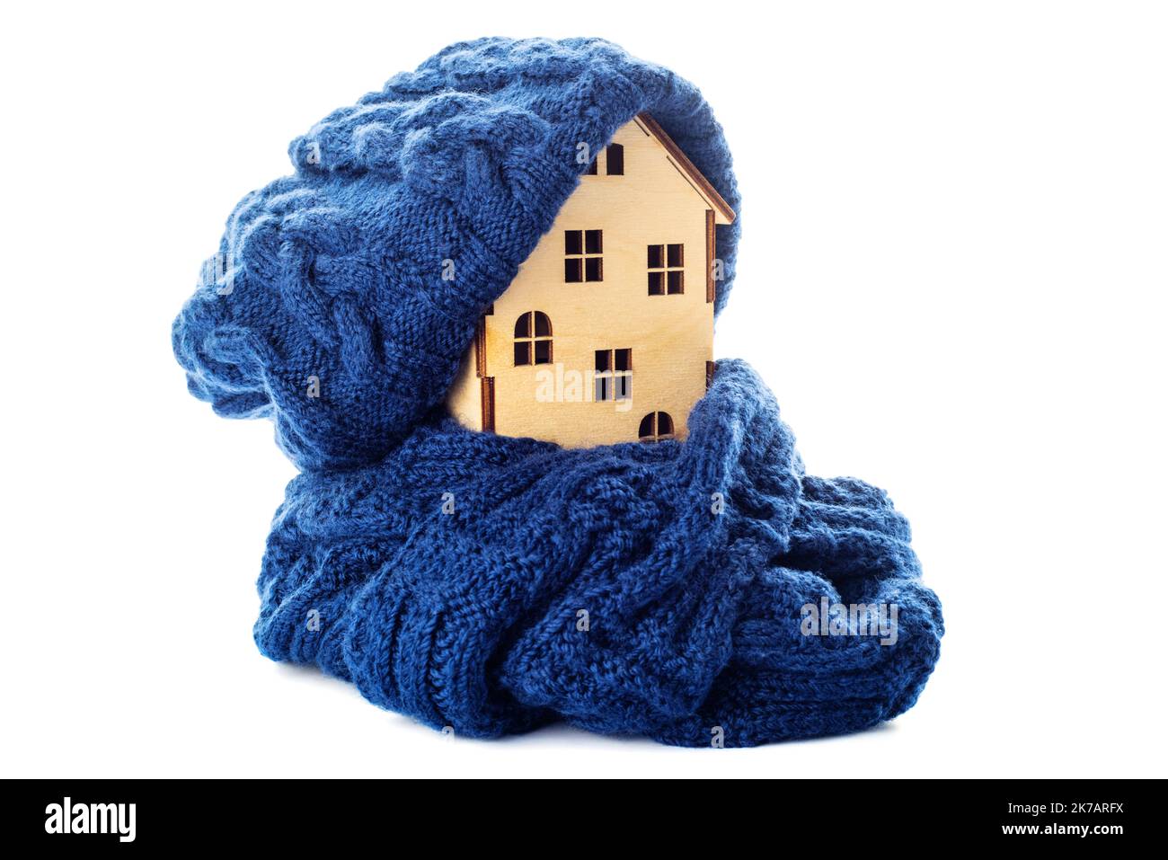 Casa giocattolo in legno con cappello caldo e sciarpa isolata su sfondo bianco Foto Stock