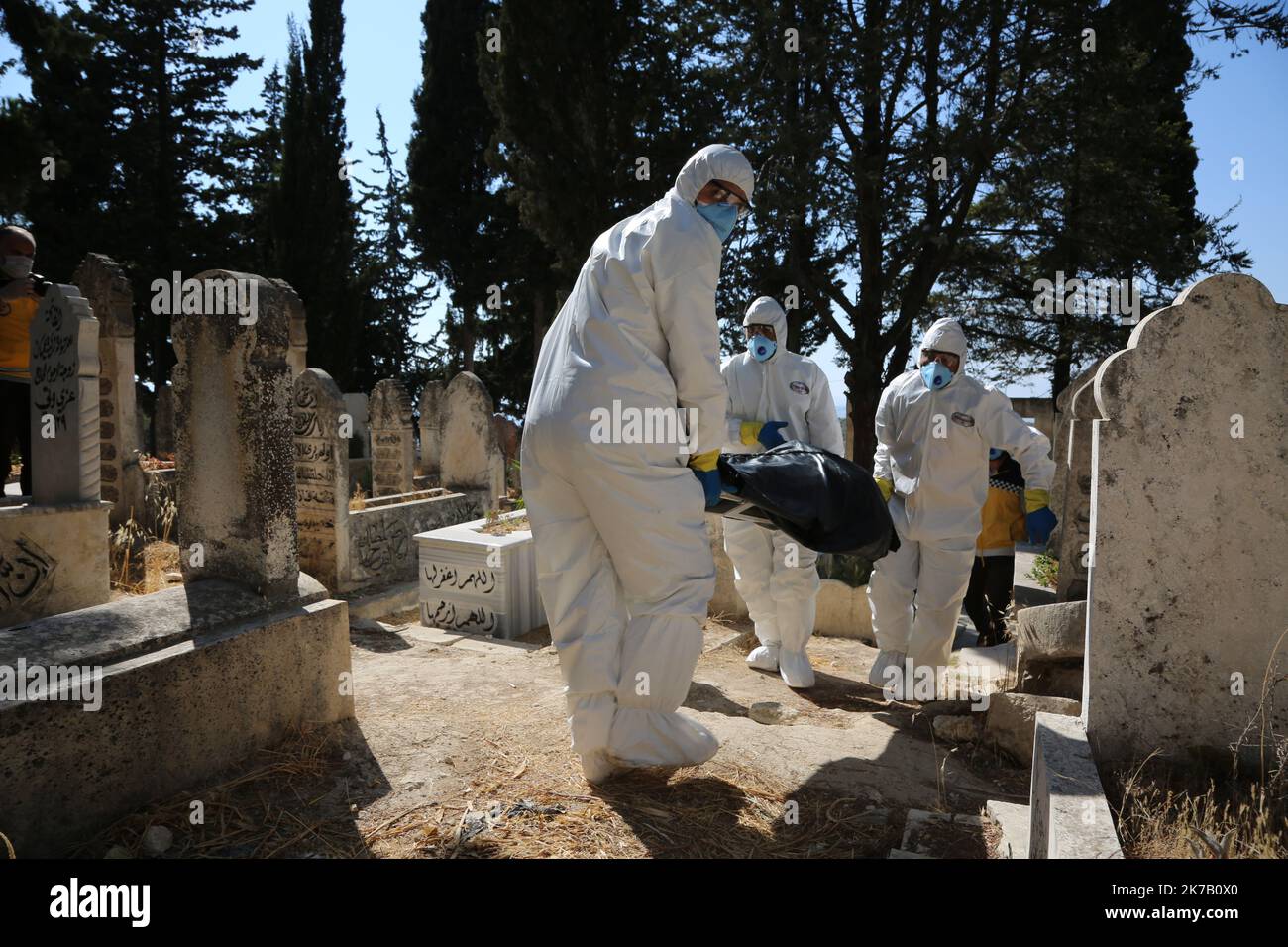 © Fadi al-Shami/MAXPPP SYRIE 17/09/2020 Des agents de santé portant des combinaisons de Protection ament le Corps d'un Syrien décédé de la maladie du covid-19 dans une tombe, dans la ville de Salqin, dans la provincia sirienne du nord-ouest d'Idlib, le 17 settembre 2020. Gli operatori sanitari che indossano tute protettive abbassano il corpo un uomo siriano di 62 anni sfollato morto per la malattia del covid-19 in una tomba, nella città di Salqin, nella provincia nordoccidentale dell'Idlib siriano, il 17 settembre 2020. Foto Stock