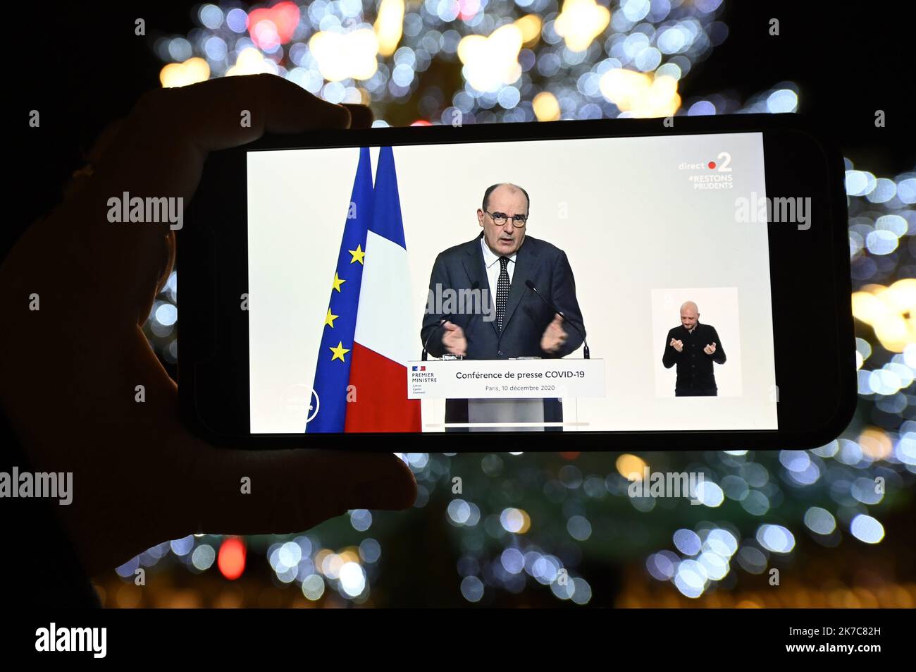 ©PHOTOPQR/L'EST REPUBLICAIN/ALEXANDRE MARCHI ; NANCY ; 10/12/2020 ; SANTE - POINT PRESSE COVID 19 - CORONAVIRUS - TELEVISIONE. Nancy 10 dicembre 2020. Sur un téléphone portable, sous les lumières du sapin de Noël de la Place Stanislas, le point presse télévisé du Premier ministre, Jean CASTEX, sur les nouvelles mesures de déconfinement et de couvre-feu à partir du 15 décmebre et pour les fêtes alors que le nombre de contaminations quotidiennes ne recule plus. FOTO Alexandre MARCHI. 2020/12/10. Su un telefono cellulare, sotto le luci dell'albero di Natale in Piazza Stanislas, la stampa televisiva Foto Stock