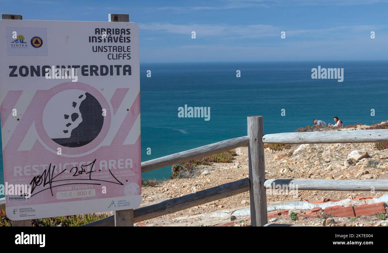 La gente ignora un segnale di avvertimento per non attraversare una pericolosa zona ristretta vicino Sintra, Portogallo Foto Stock