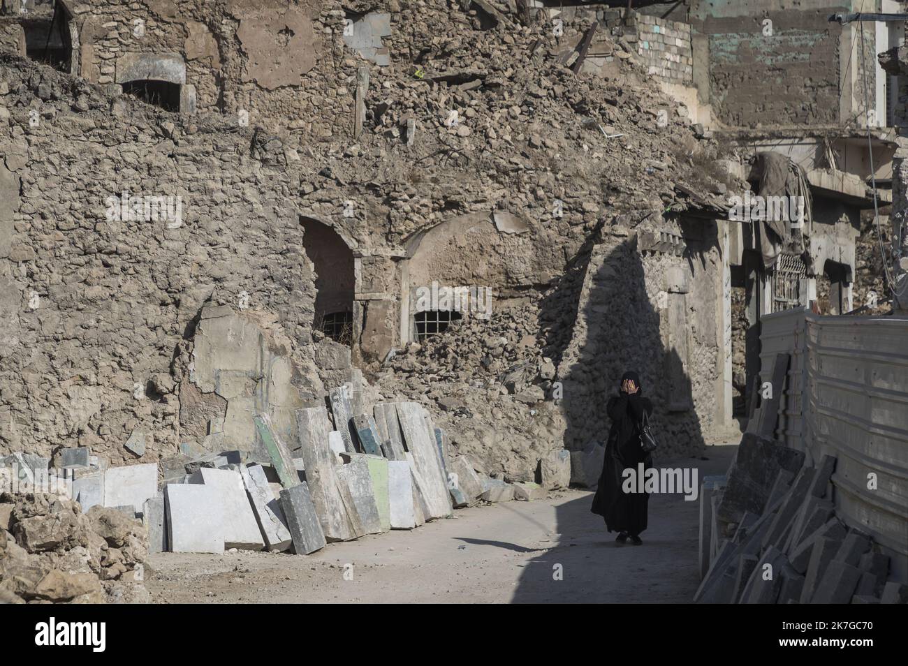 ©Christophe Petit Tesson/MAXPPP - 27/11/2021 ; MOSUL ; IRAQ - une femme se cache le visage en marchant dans une rue d'un quartier en reconstruction dans la vieille ville de Mossoul. La ville de Mossoul, liberee de l'Etat Islamique en Juillet 2017, a subi d'importantes distruzioni urbaines et se releve petit a petit avec l'aide de projets internatationaux sous l'egide de l'Unesco. Una donna cammina in una strada nella Città Vecchia di Mosul sotto ricostruzione. La città di Mosul, liberata dallo Stato Islamico nel luglio 2017, ha subito una significativa distruzione urbana e si sta gradualmente riprendendo con il th Foto Stock