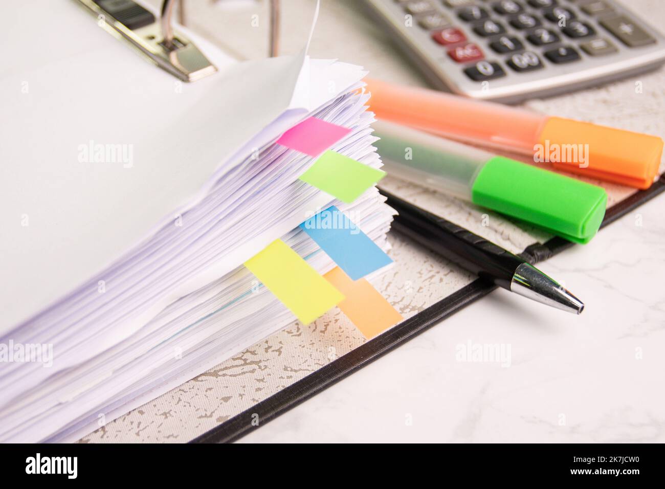 documentare il foglio grafico a colori per la presentazione sul tavolo della sala in ufficio con la calcolatrice dell'attrezzatura, la matita, la penna a colori evidenziata Foto Stock