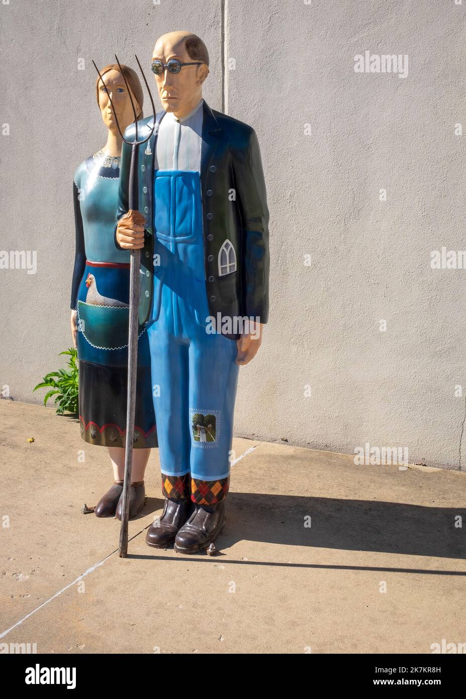 Casa Gotica americana di Grant Wood, Eldon, Iowa; statue di uomo e donna con forchetta Foto Stock