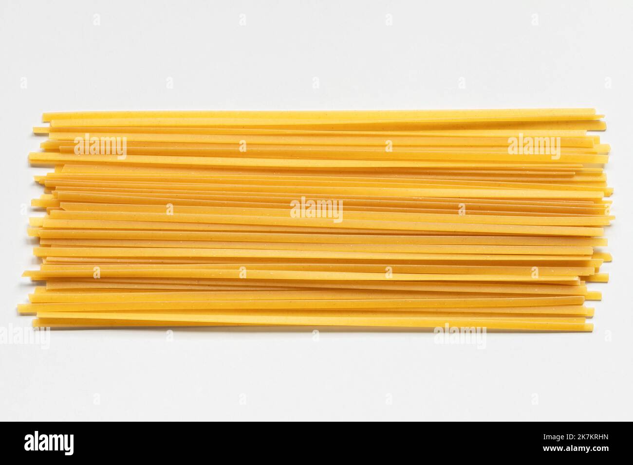 Pasta fettuccina di durum su fondo bianco. Spaghetti o tagliatelle crudi Foto Stock