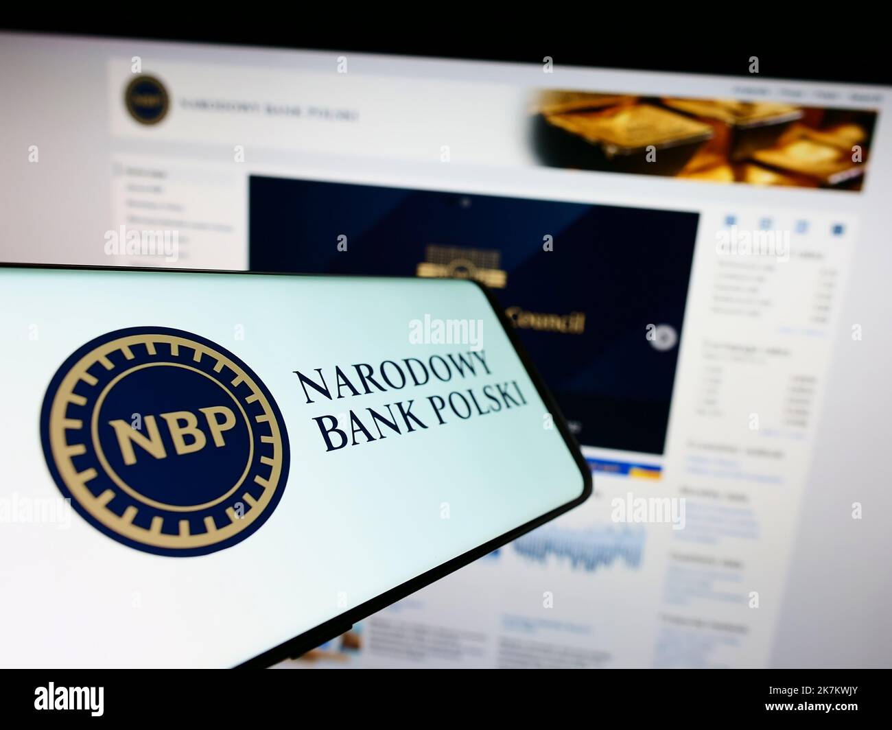 Smartphone con logo della banca centrale polacca Narodowy Bank Polski (NBP) sullo schermo di fronte al sito Web. Messa a fuoco al centro del display del telefono. Foto Stock