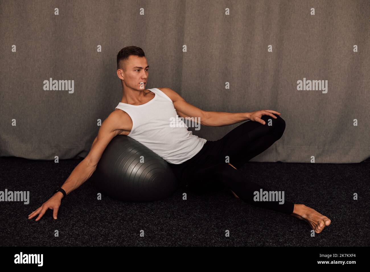 Un giovane atleta esegue esercizi a casa. Fitness Fitball Yoga Pilates Foto Stock