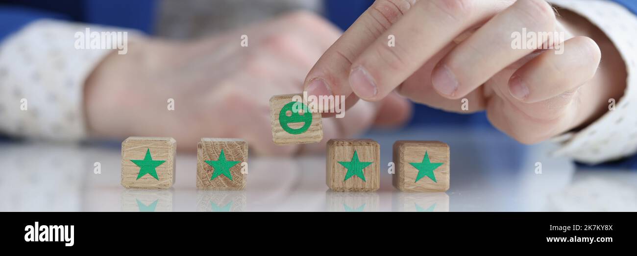 Il cliente sta tenendo sorridente faccia sorridente sul cubo di legno Foto Stock