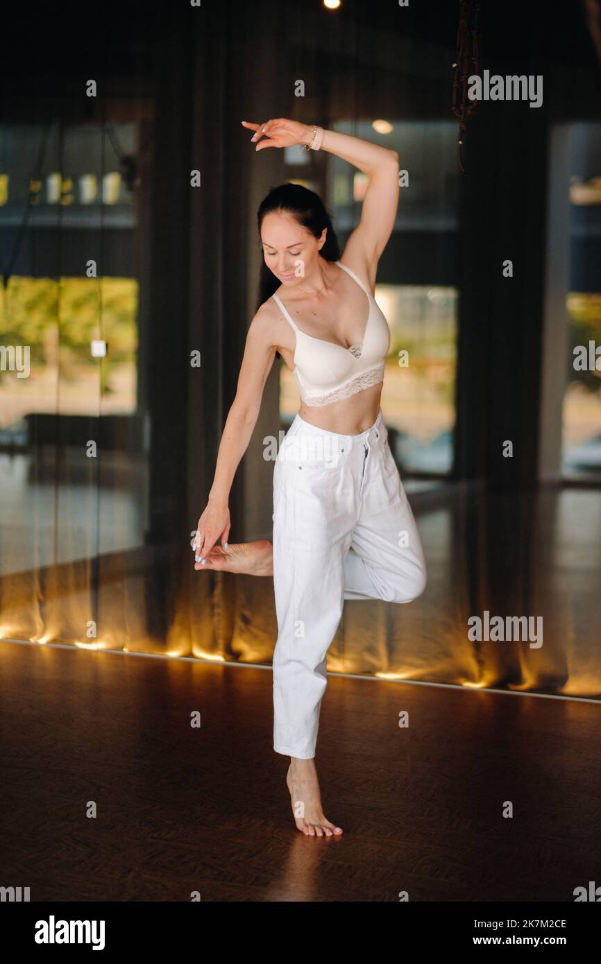 Ritratto di una donna in abiti bianchi che danzano in piedi all'interno Foto Stock