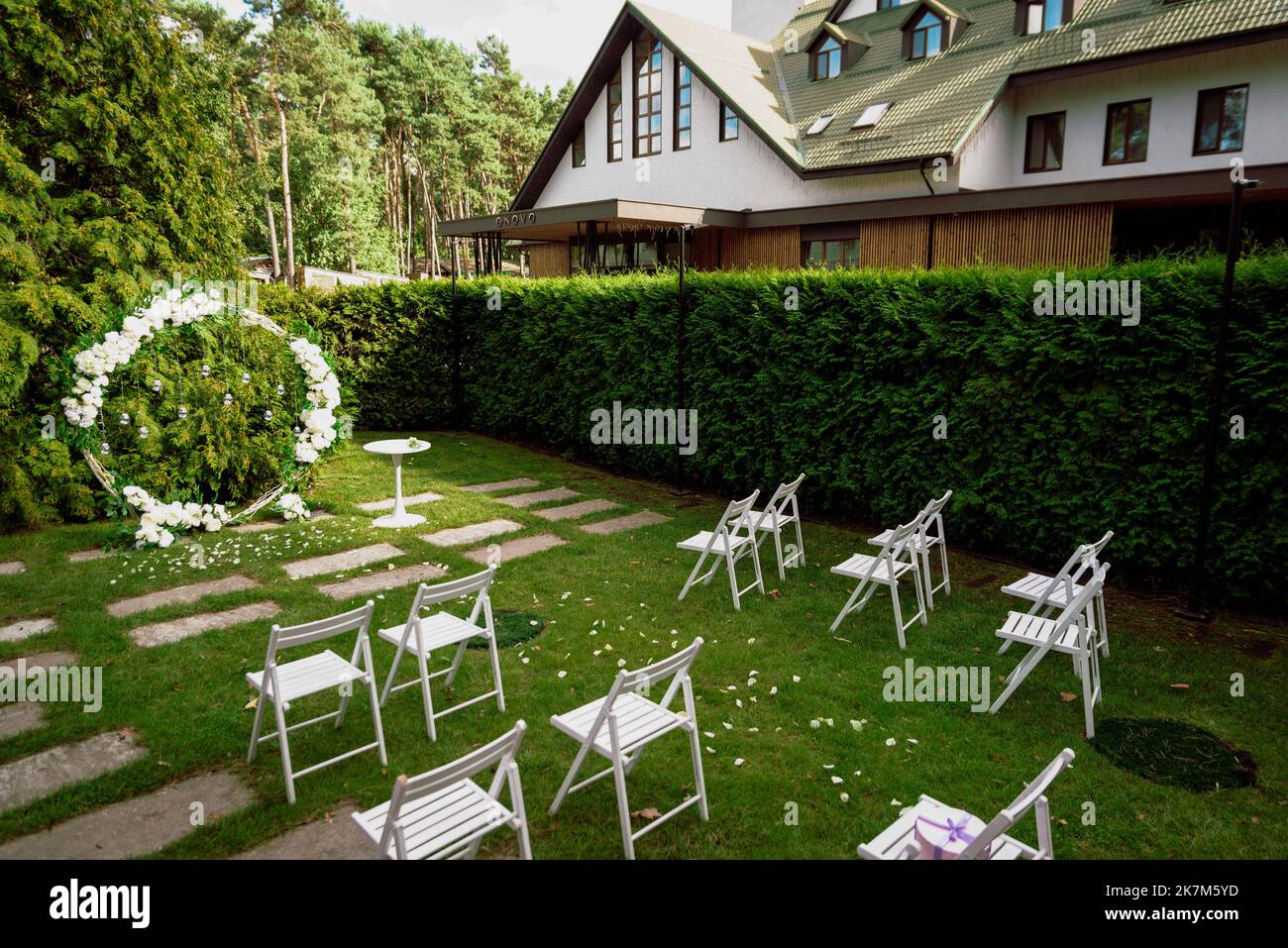 Cerimonia nuziale. Molto bello ed elegante arco di nozze, decorato con vari fiori freschi, in piedi nel giardino. Giorno di nozze. Fiori freschi de Foto Stock