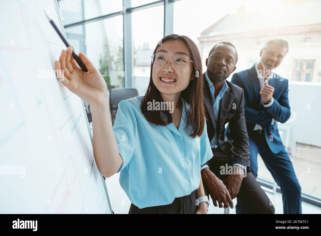 Gruppo di uomini d'affari multietnici che lavorano insieme sul progetto mentre si siedono in un ufficio moderno Foto Stock