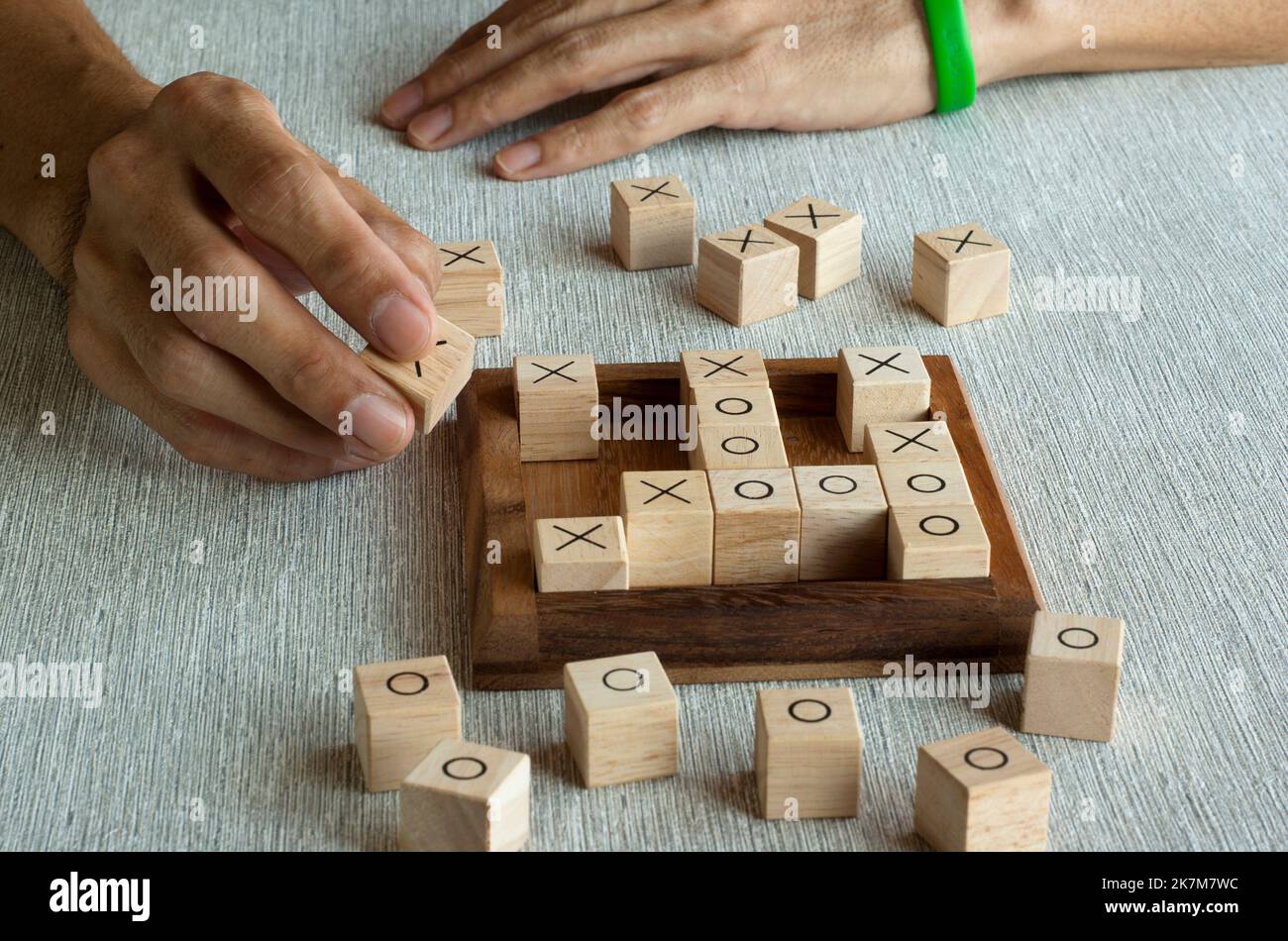 TIC tac TOE OX gioco fatto di blocchi di legno con giocatore a mano Foto Stock