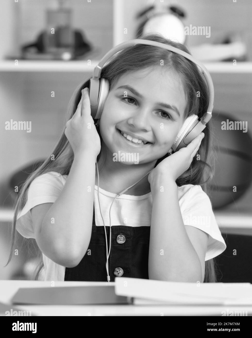 il bambino è felice di ascoltare la musica in cuffia in classe scolastica Foto Stock