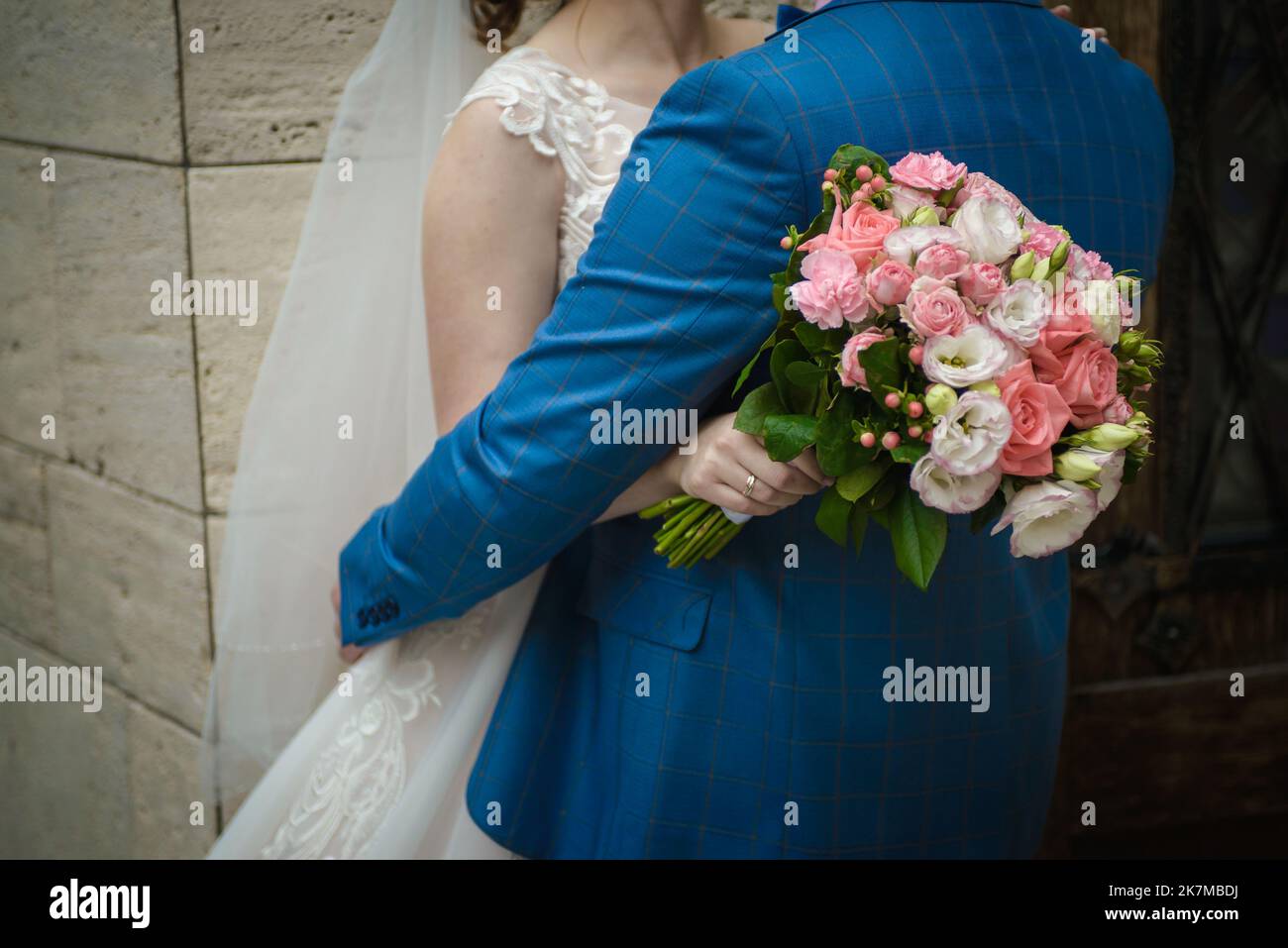 La sposa tiene un bouquet di nozze dalle rose nelle sue mani, fiori di giorno di nozze. Bel bouquet di fiori bohémien matrimonio. Ragazza in un abito con un bouq Foto Stock