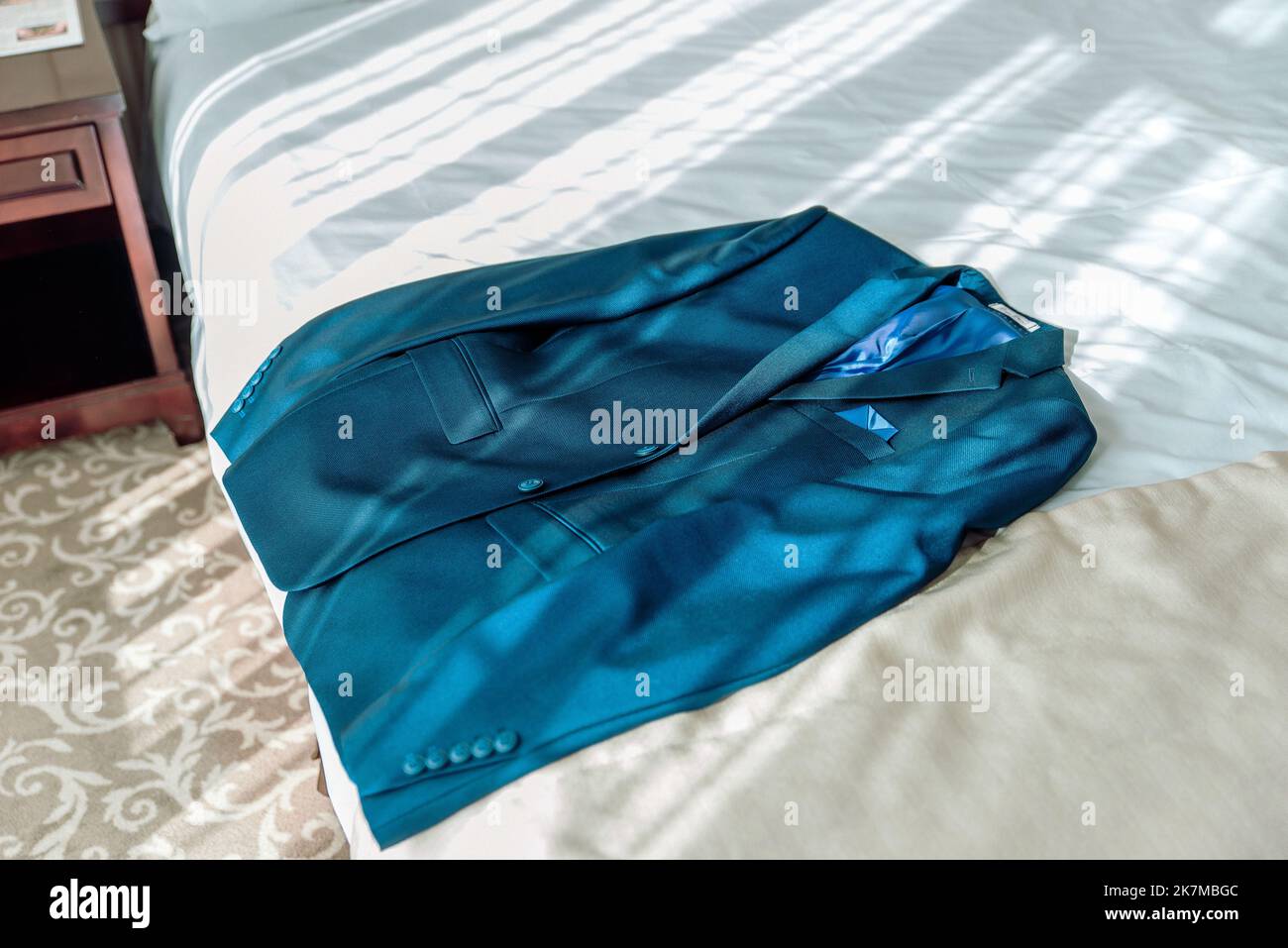 Elegante tuta da sposa con appendiabiti nell'appartamento dell'hotel. Accessori sposi per matrimoni. Foto Stock