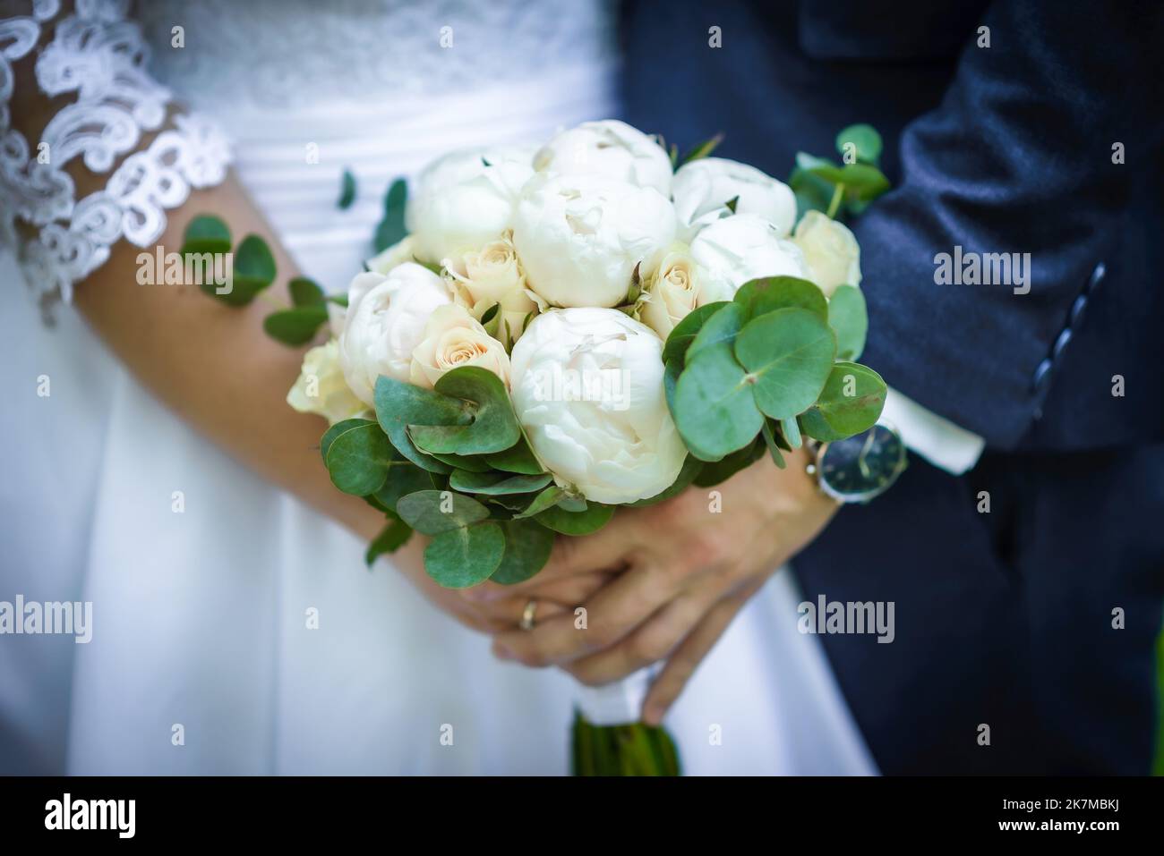 La sposa tiene un bouquet di nozze dalle rose nelle sue mani, fiori di giorno di nozze. Bel bouquet di fiori bohémien matrimonio. Ragazza in un abito con un bouq Foto Stock