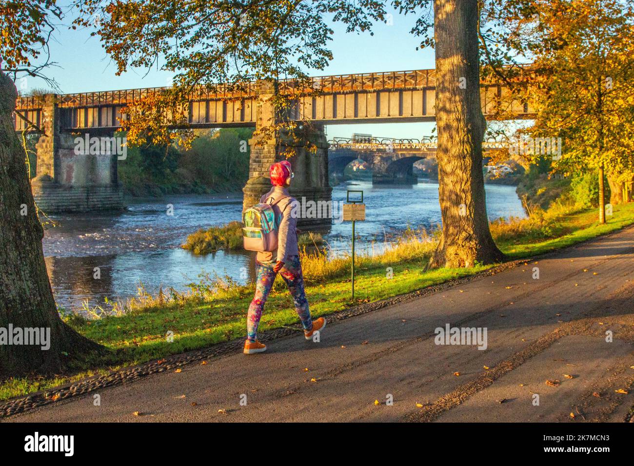 Preston, Lancashire. Meteo UK; 18 Ott 2022. Il sole sorge sopra il fiume Ribble mentre i residenti locali si allenano all'alba lungo Riverside Walk, un freddo inizio di giornata in nebbia. Avenham Park spazio per famiglie, piste ciclabili e sentieri per passeggiate nel nord-ovest dell'Inghilterra. Credit; MediaWorldImages/AlamyLiveNews Foto Stock