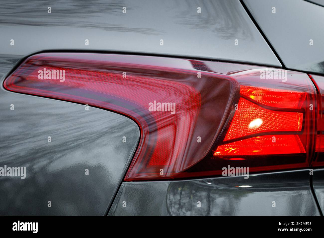 Primo piano sulla luce di posizione posteriore di un'auto grigia Foto Stock