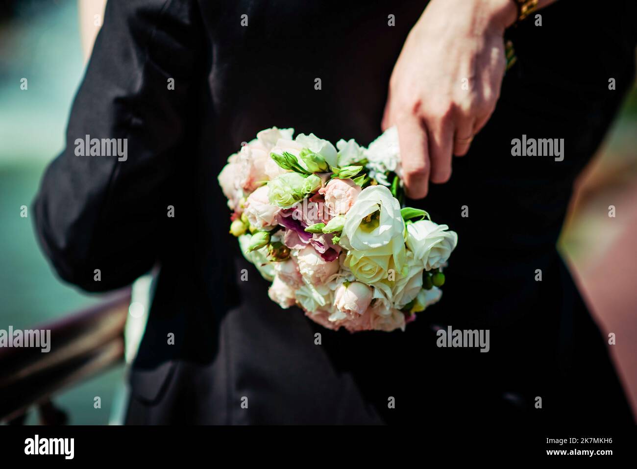 La sposa tiene un bouquet di nozze dalle rose nelle sue mani, fiori di giorno di nozze. Bel bouquet di fiori bohémien matrimonio. Ragazza in un abito con un bouq Foto Stock