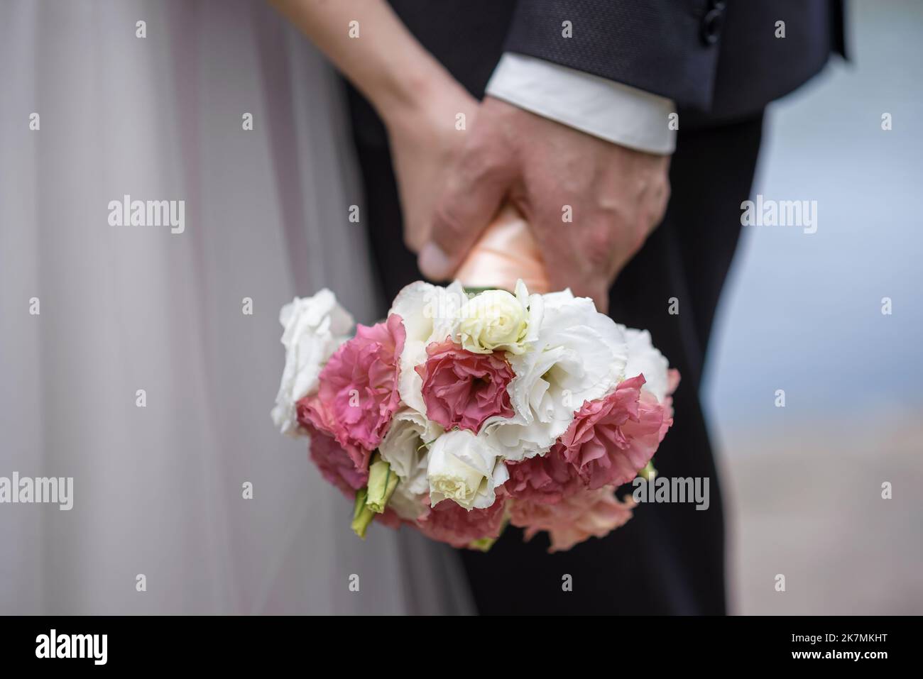 La sposa tiene un bouquet di nozze dalle rose nelle sue mani, fiori di giorno di nozze. Bel bouquet di fiori bohémien matrimonio. Ragazza in un abito con un bouq Foto Stock