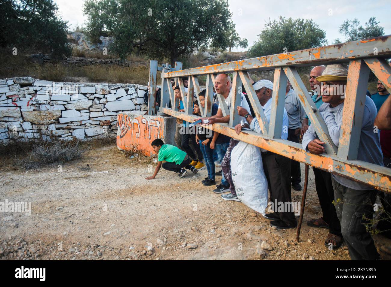 Nablus, Palestina. 18th Ott 2022. Gli agricoltori palestinesi attendono che la porta dell'insediamento israeliano di Elon Moreh venga aperta dall'esercito israeliano per raggiungere i loro campi di ulivo per raccogliere olive durante la stagione della raccolta delle olive nel villaggio di Salem, nella città di Nablus, nella sponda occidentale occupata. Credit: SOPA Images Limited/Alamy Live News Foto Stock