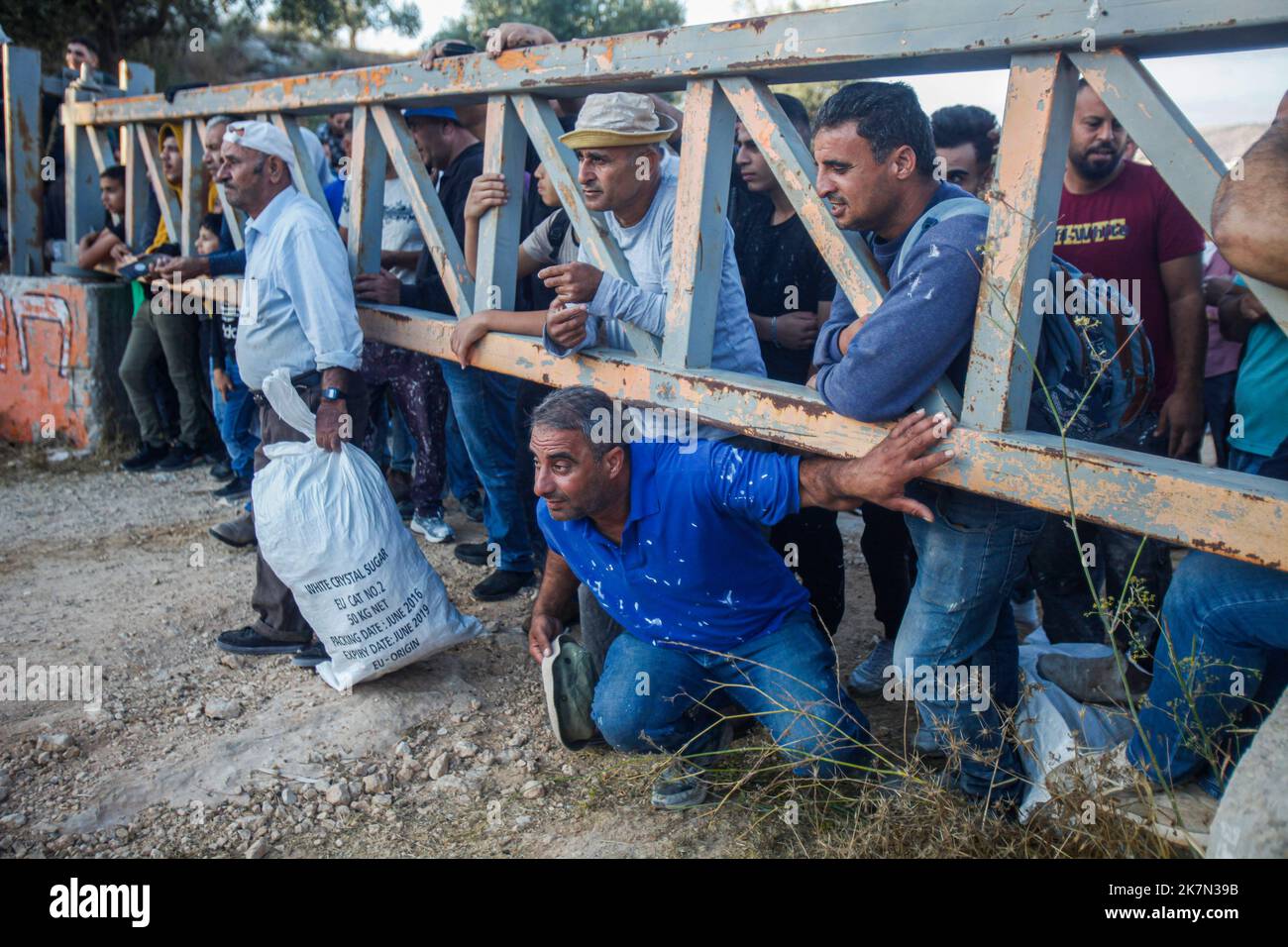 Nablus, Palestina. 18th Ott 2022. Gli agricoltori palestinesi attendono che la porta dell'insediamento israeliano di Elon Moreh venga aperta dall'esercito israeliano per raggiungere i loro campi di ulivo per raccogliere olive durante la stagione della raccolta delle olive nel villaggio di Salem, nella città di Nablus, nella sponda occidentale occupata. Credit: SOPA Images Limited/Alamy Live News Foto Stock