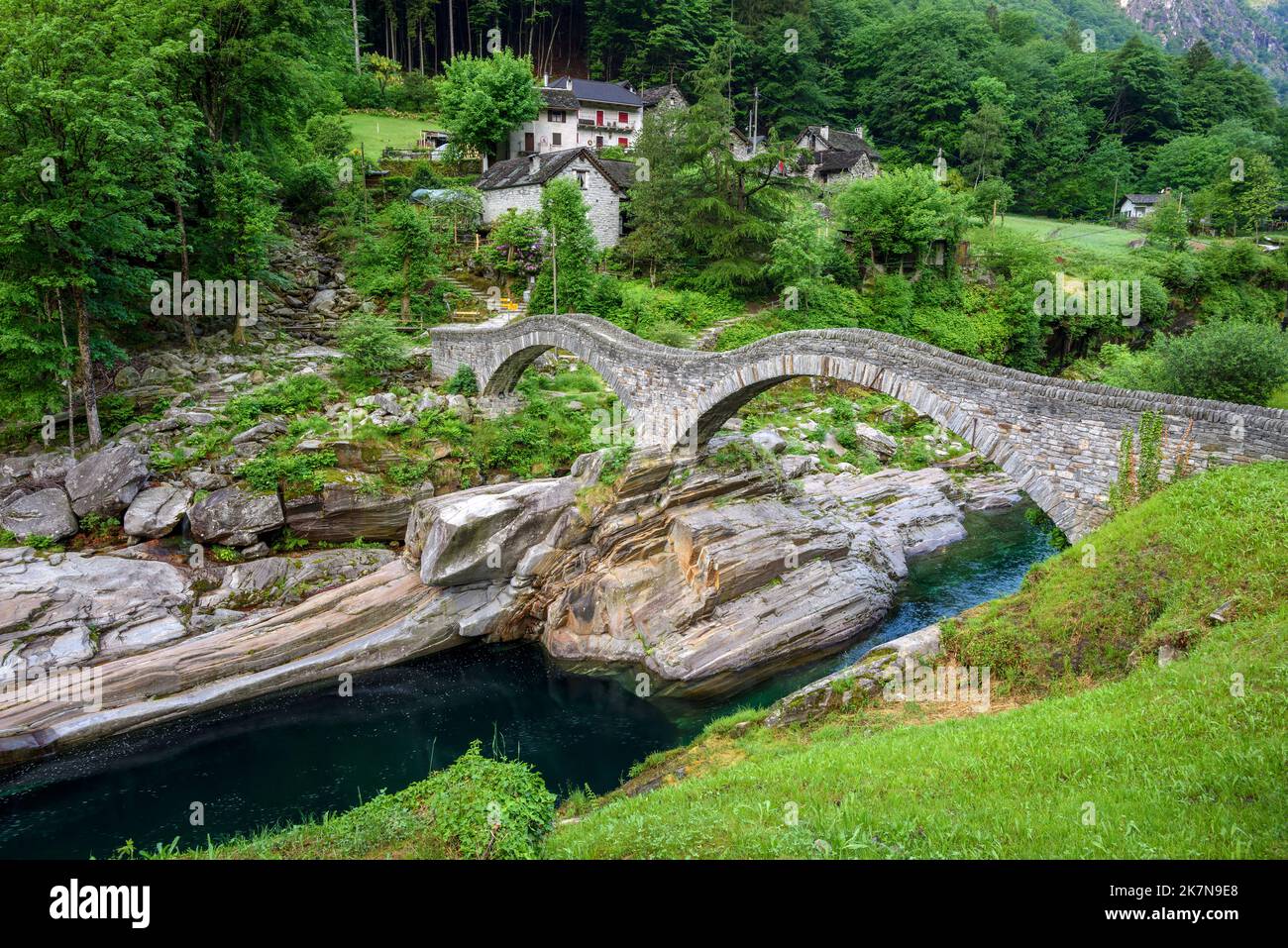 Romantico ponte dei sali in pietra nel villaggio di Lavertezzo, valle Verzasca sulle Alpi svizzere, Svizzera Foto Stock