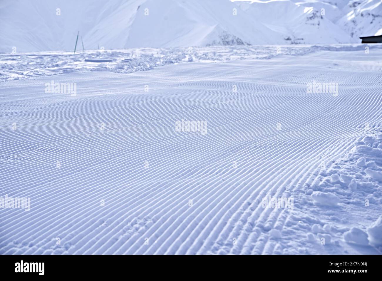 Linee di neve dopo la pista da neve presso la stazione sciistica. La pista da sci fresca e pronta sembra neve di velluto. Pista da sci curata. Foto Stock