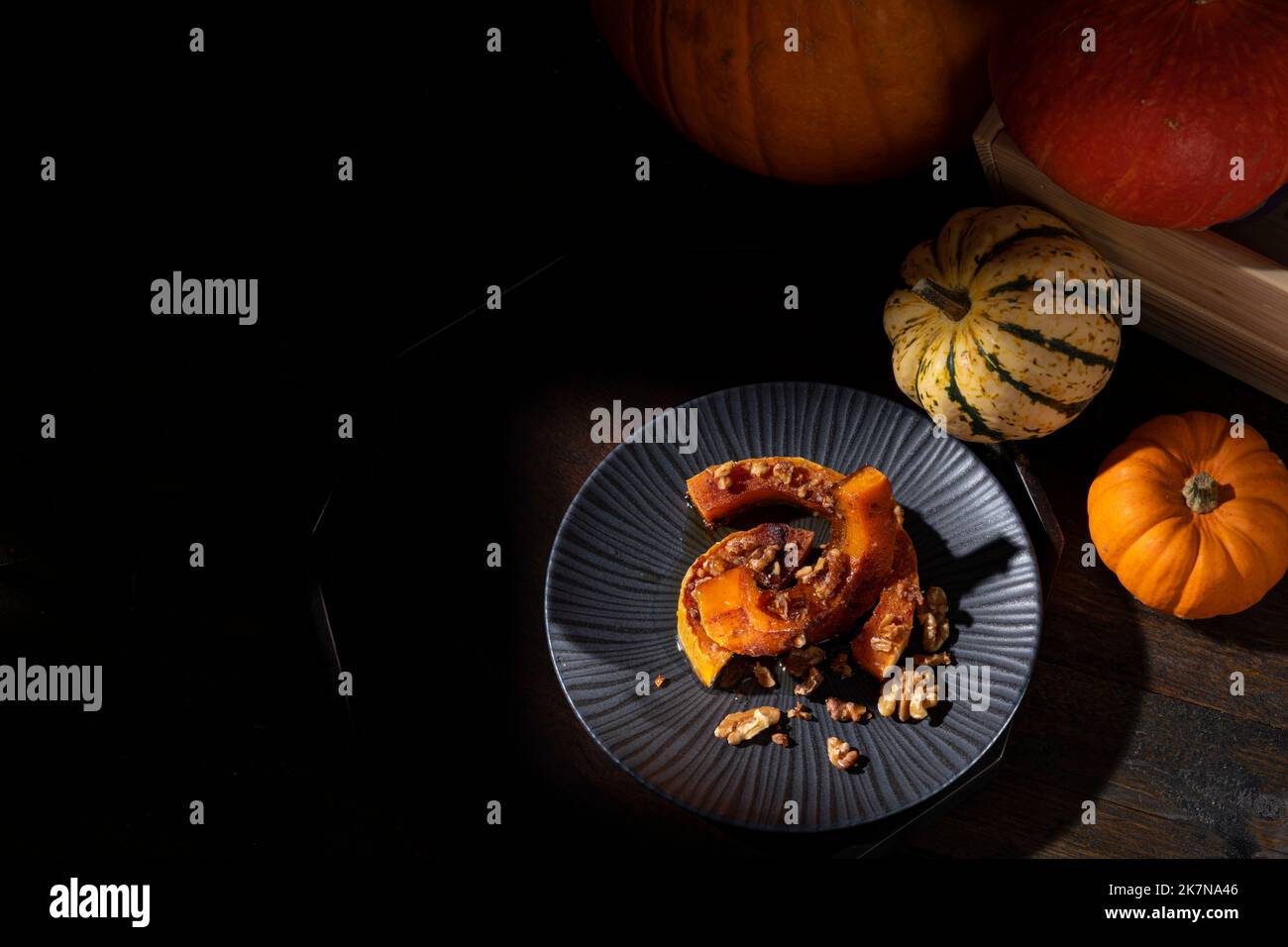 Scuro moody pittorico fermo-vita di autunno arrosto zucca zucca zucca zucca zucca zucca spolverata con cannella, noci e miele Foto Stock