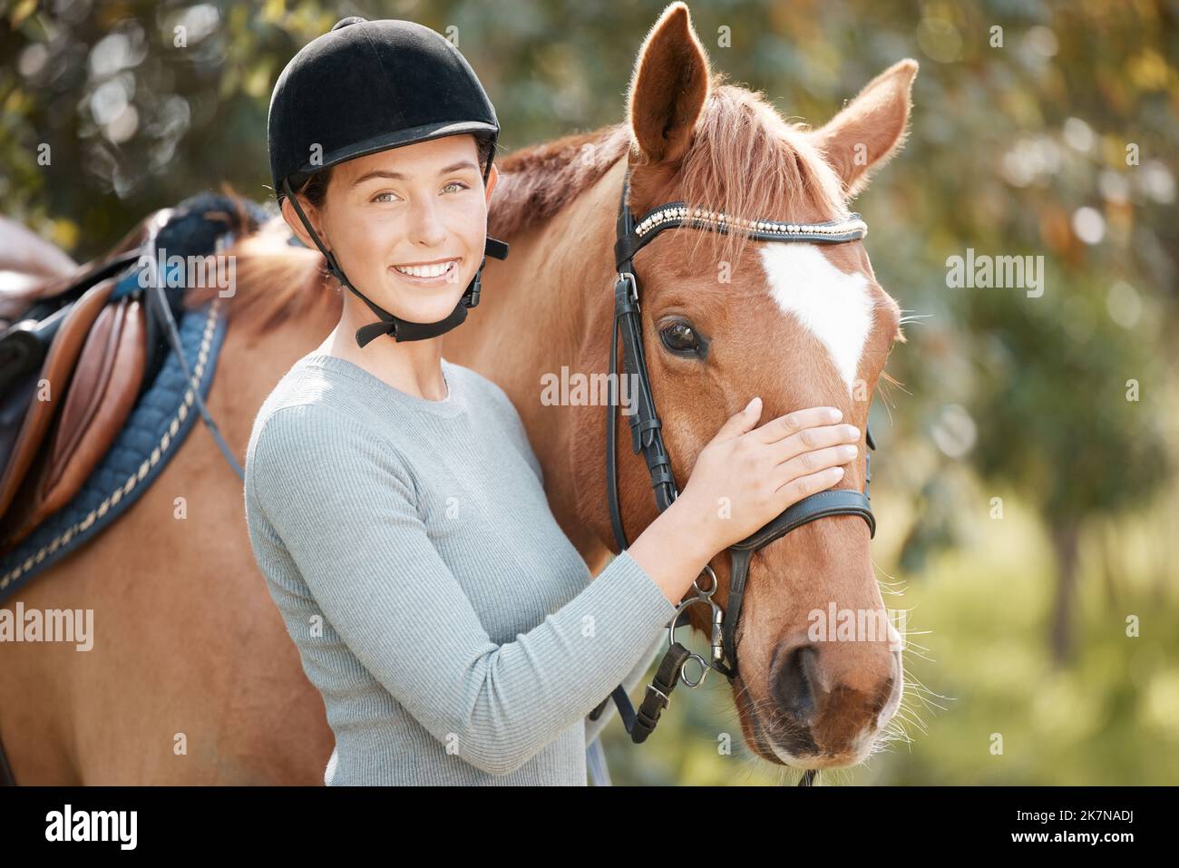 I cavalli danno ai nostri giovani fiducia e autostima. una giovane donna attraente in piedi con il suo cavallo in una foresta. Foto Stock