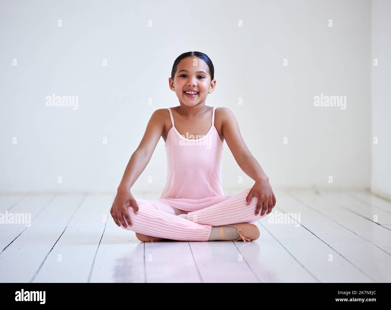 Alcune ragazze sono appena sopportate con i glitter nelle loro vene. Ritratto di una bambina seduta con le gambe incrociate in uno studio di balletto. Foto Stock