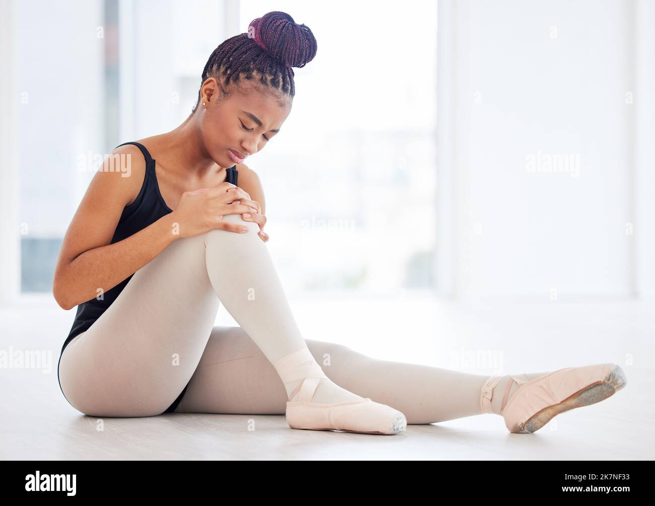 Devo lavorare sul mio equilibrio. una giovane ballerina che tiene la gamba in dolore. Foto Stock
