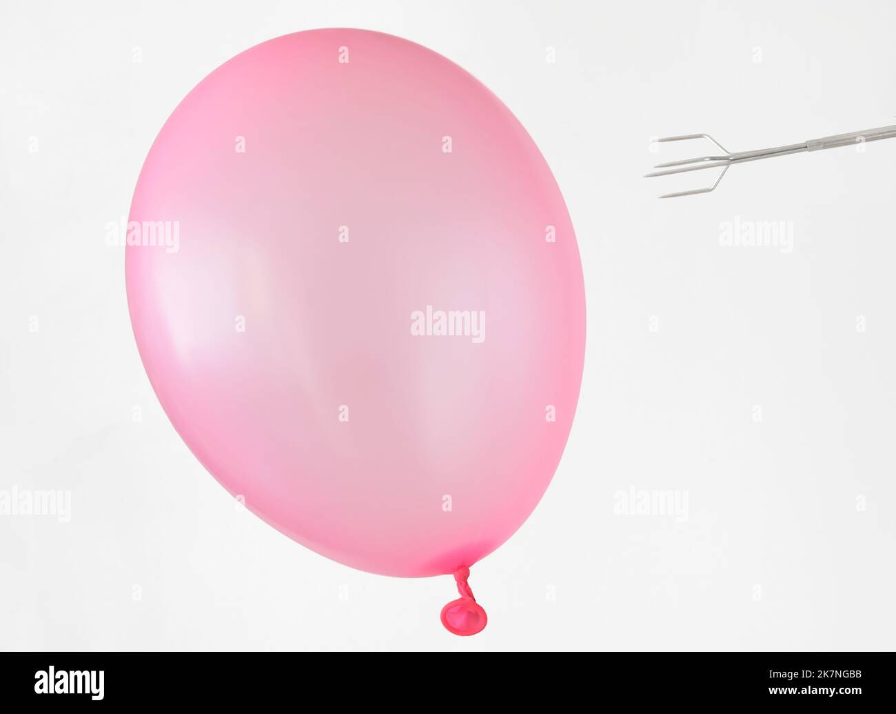 Un ballon e una fork, rischio, coraggio, risoluzione dei problemi e risoluzione dei problemi aziendali metafora o concetto.sfondo bianco buona copia spazio. Foto Stock