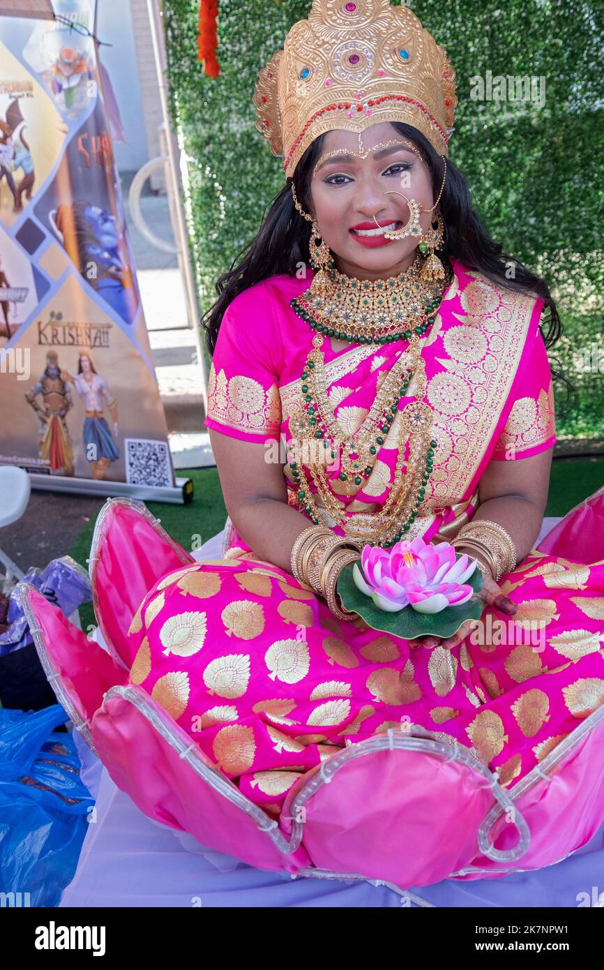 Alla celebrazione di Diwali 2022 una donna molto graziosa si pone seduto in & tenendo un fiore di loto. Sulla Liberty Ave a Richmond Hill, New York Foto Stock