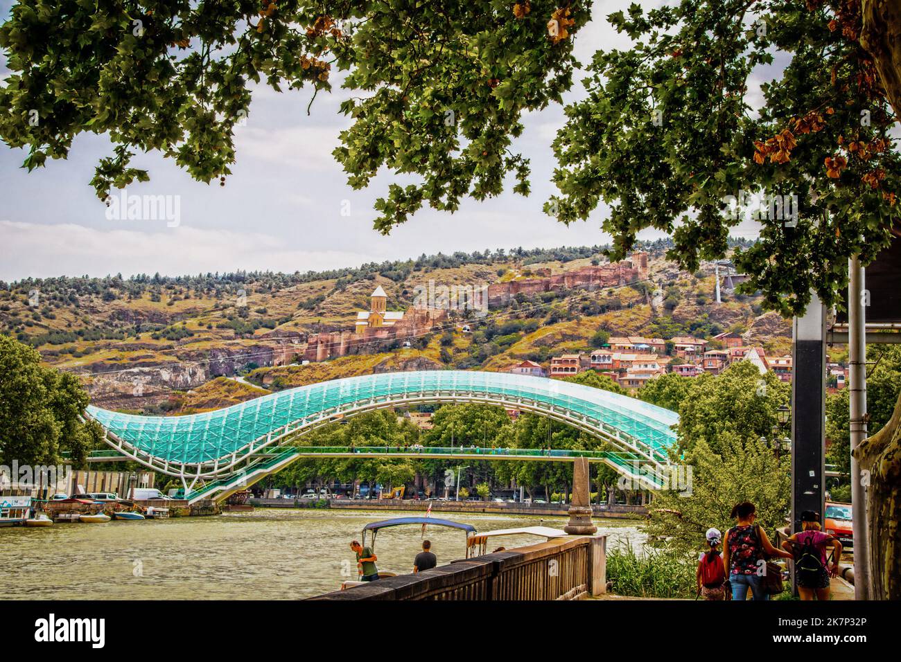 07 19 2019 Tbilisi Georgia - Vista panoramica del Ponte della Pace con funivie che viaggiano su e giù per la fortezza di Narikala e barche e barcaioli sul fiume Foto Stock