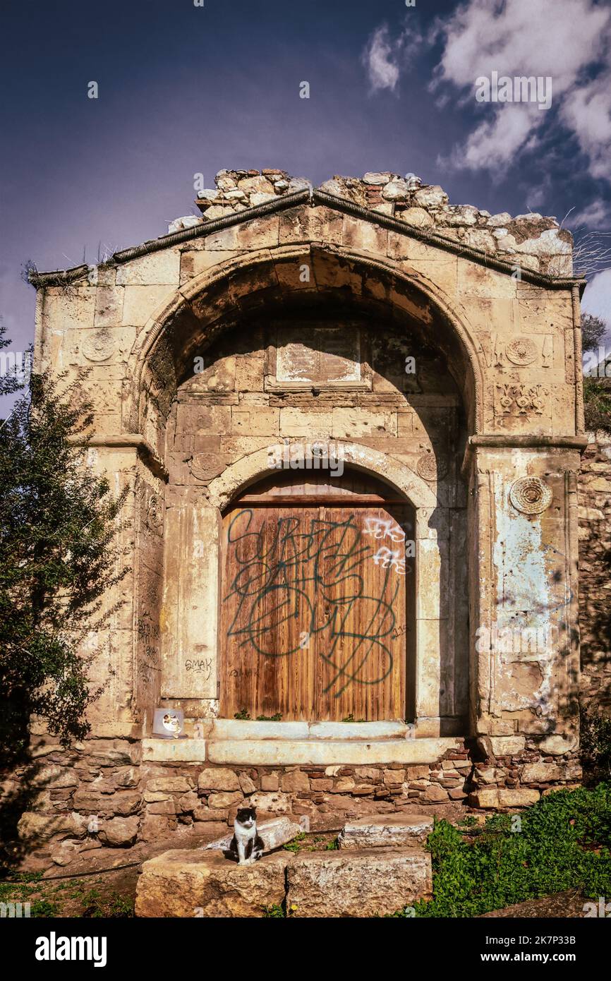 2018 -01 03  Atene Grecia - piccolo edificio antico vicino ad Acropoli e Torre dei Venti ad Atene con porta a bordo e gatto seduto sulle rocce di fronte Foto Stock
