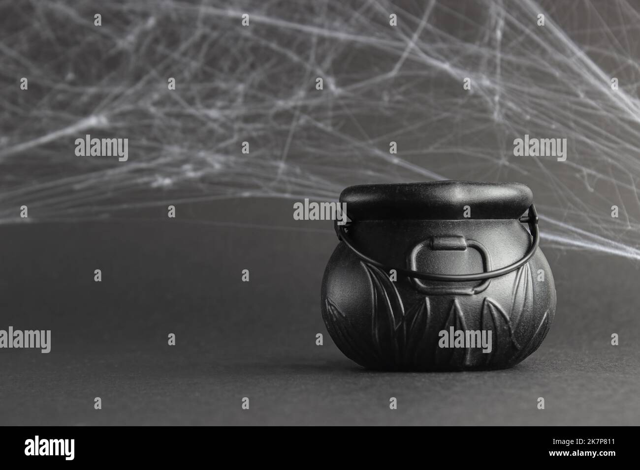 fake witch's cauldron, su sfondo nero con ciottoli. concetto di halloween Foto Stock
