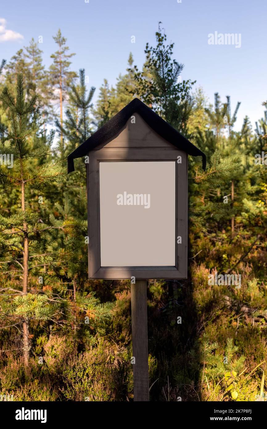 Vuoto segno bianco in natura, con alberi verdi sullo sfondo Foto Stock