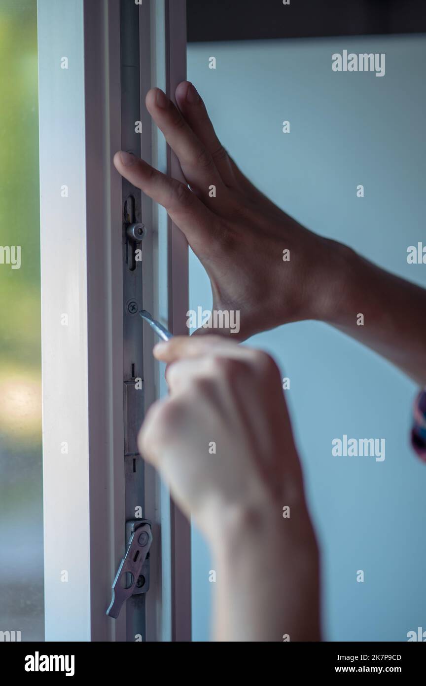 Le mani di un addetto alla manutenzione che monta il finestrino Foto Stock