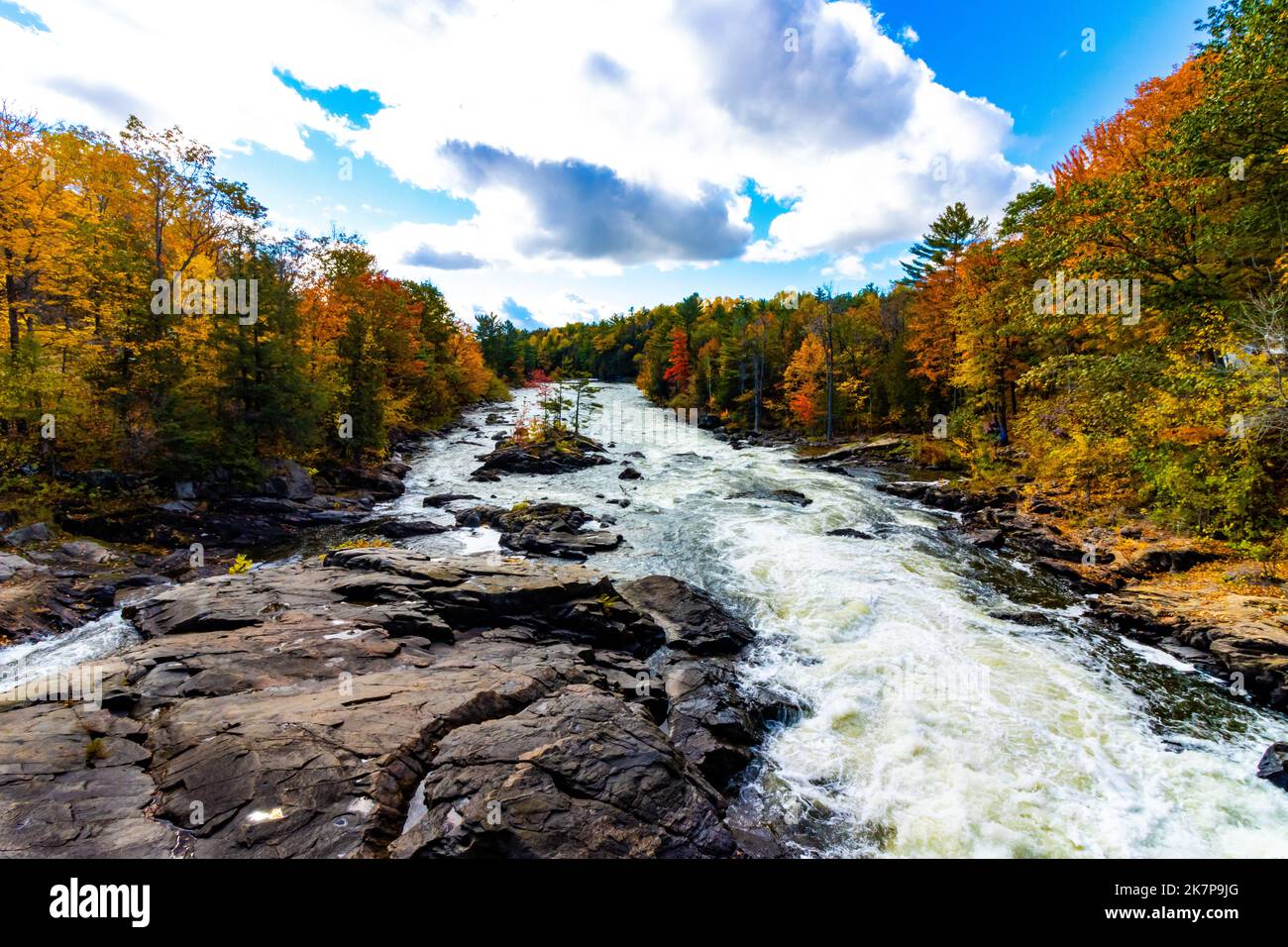 Una vista lungo il fiume della radianza della caduta e del flusso turbolento di un fiume sopra il paesaggio roccioso. Foto Stock