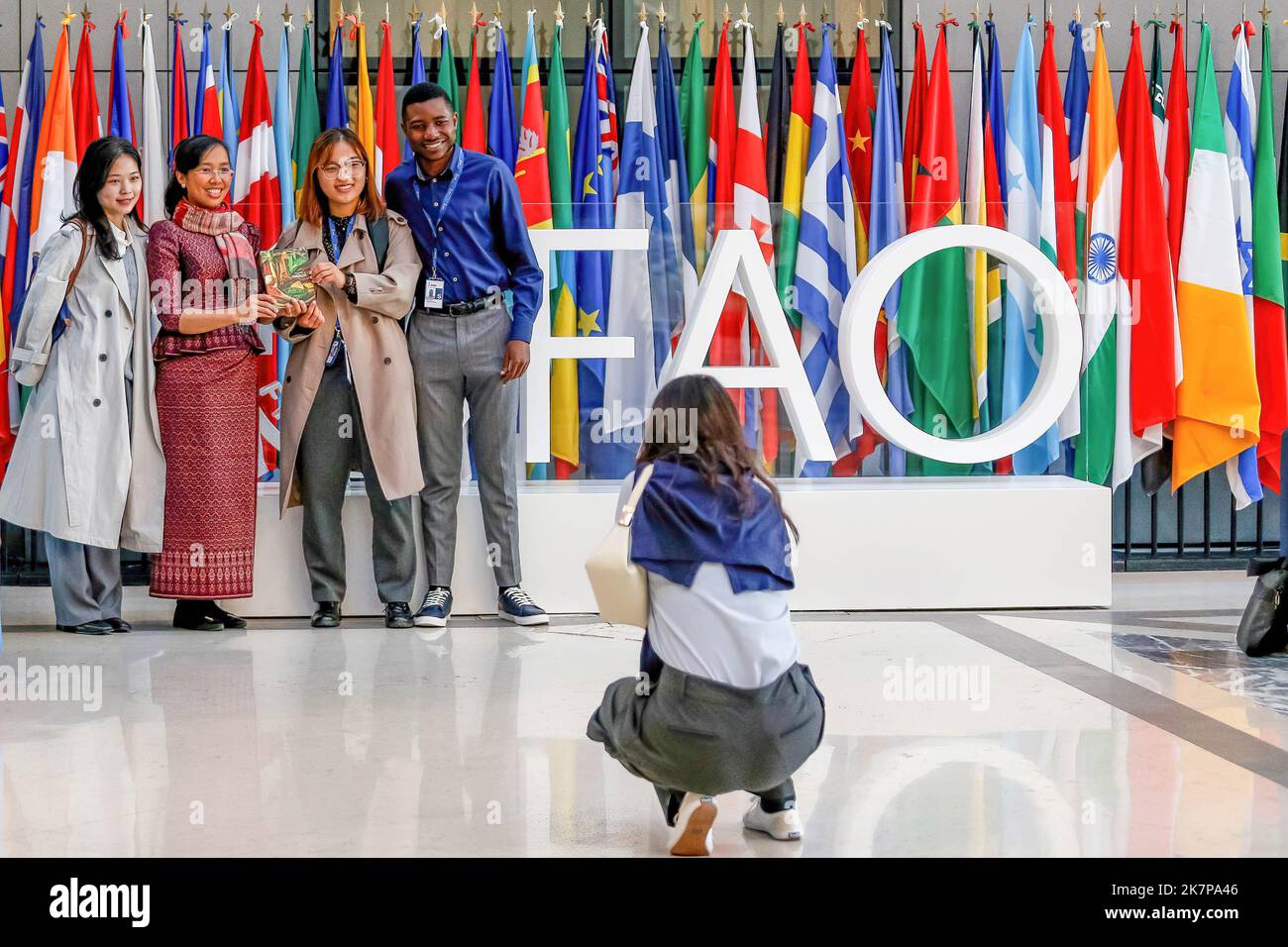 Roma, Italia. 18th Ott 2022. I partecipanti posano per le foto il logo della FAO e le bandiere delle Nazioni Unite quando arrivano durante il lancio della campagna giovanile indigena. WFF (World Food Forum) sessione di apertura del Forum Mondiale della Gioventù il giorno 2 organizzato dall'Organizzazione delle Nazioni Unite per l'alimentazione e l'agricoltura presso la sede della FAO a Roma. World Food Forum è una nuova iniziativa che si concentra sulla sicurezza alimentare globale, forum di quest'anno il pensiero principale è dieta sana. Pianeta sano. Credit: SOPA Images Limited/Alamy Live News Foto Stock