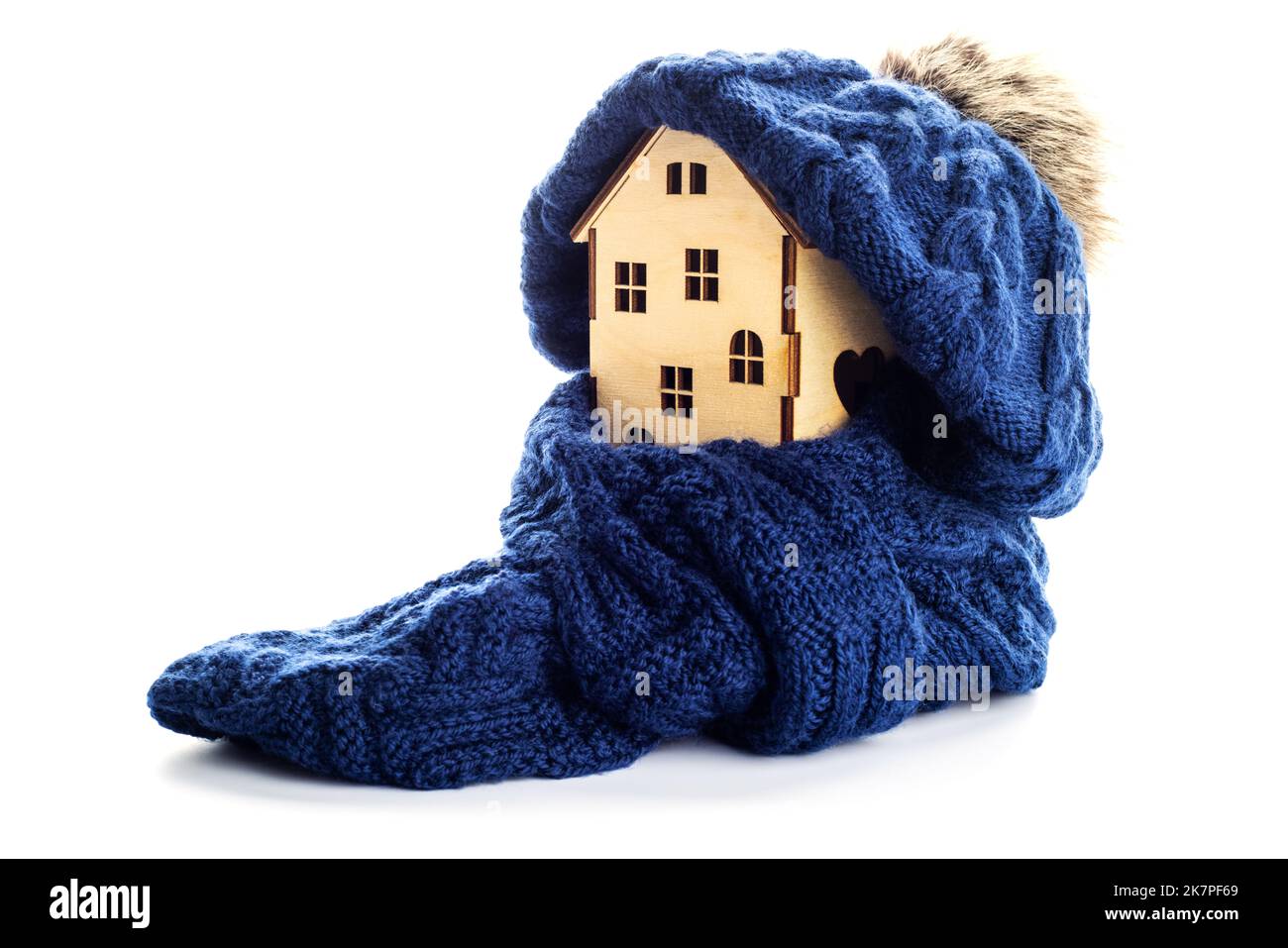 Casa giocattolo in legno con cappello caldo e sciarpa isolata su sfondo bianco Foto Stock