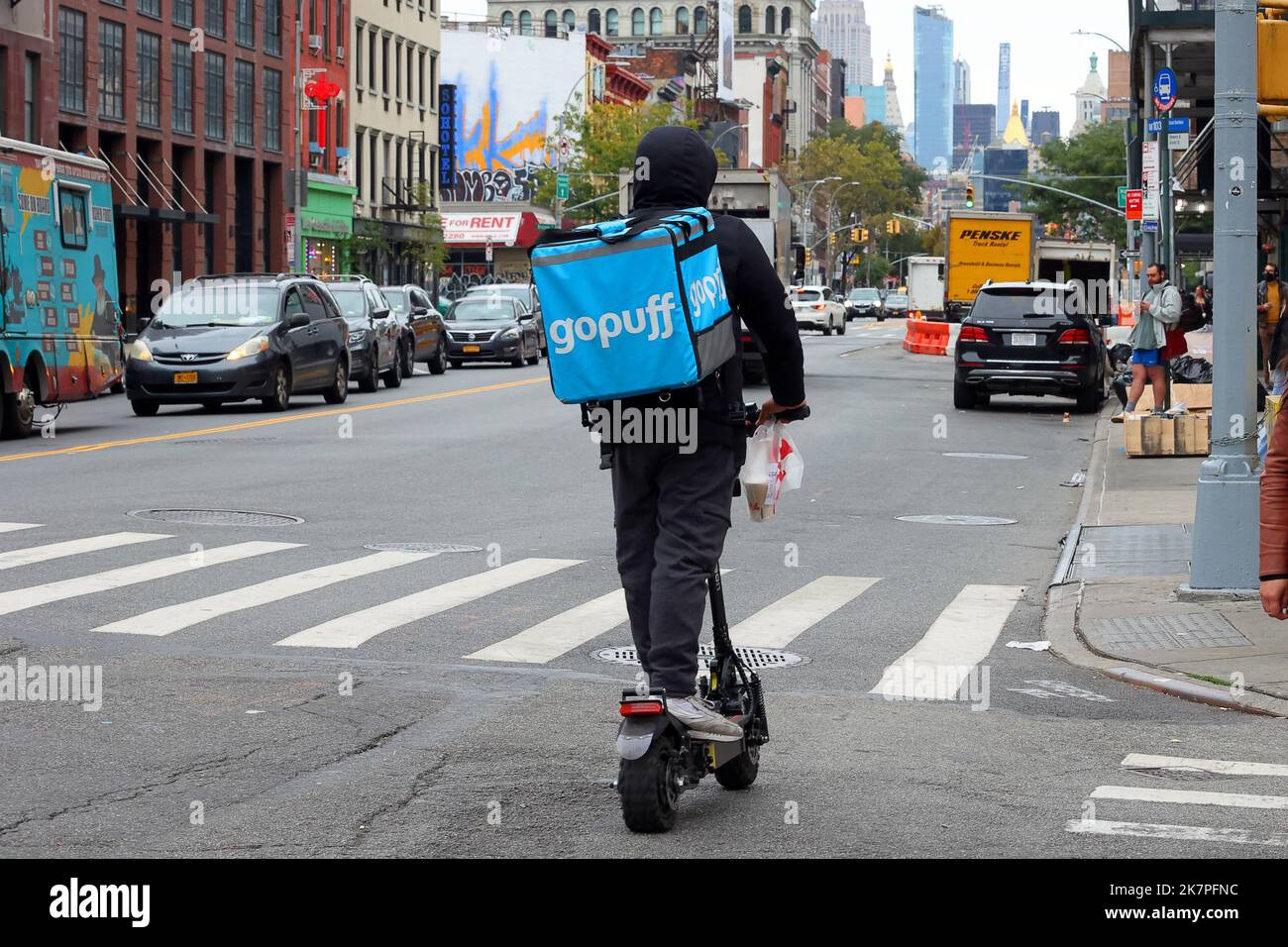 Una persona di consegna di Gopuff su uno scooter e che fa un'esigenza istantanea, richiesta rapida, consegna su richiesta a New York. parte del commercio rapido o del commercio q Foto Stock